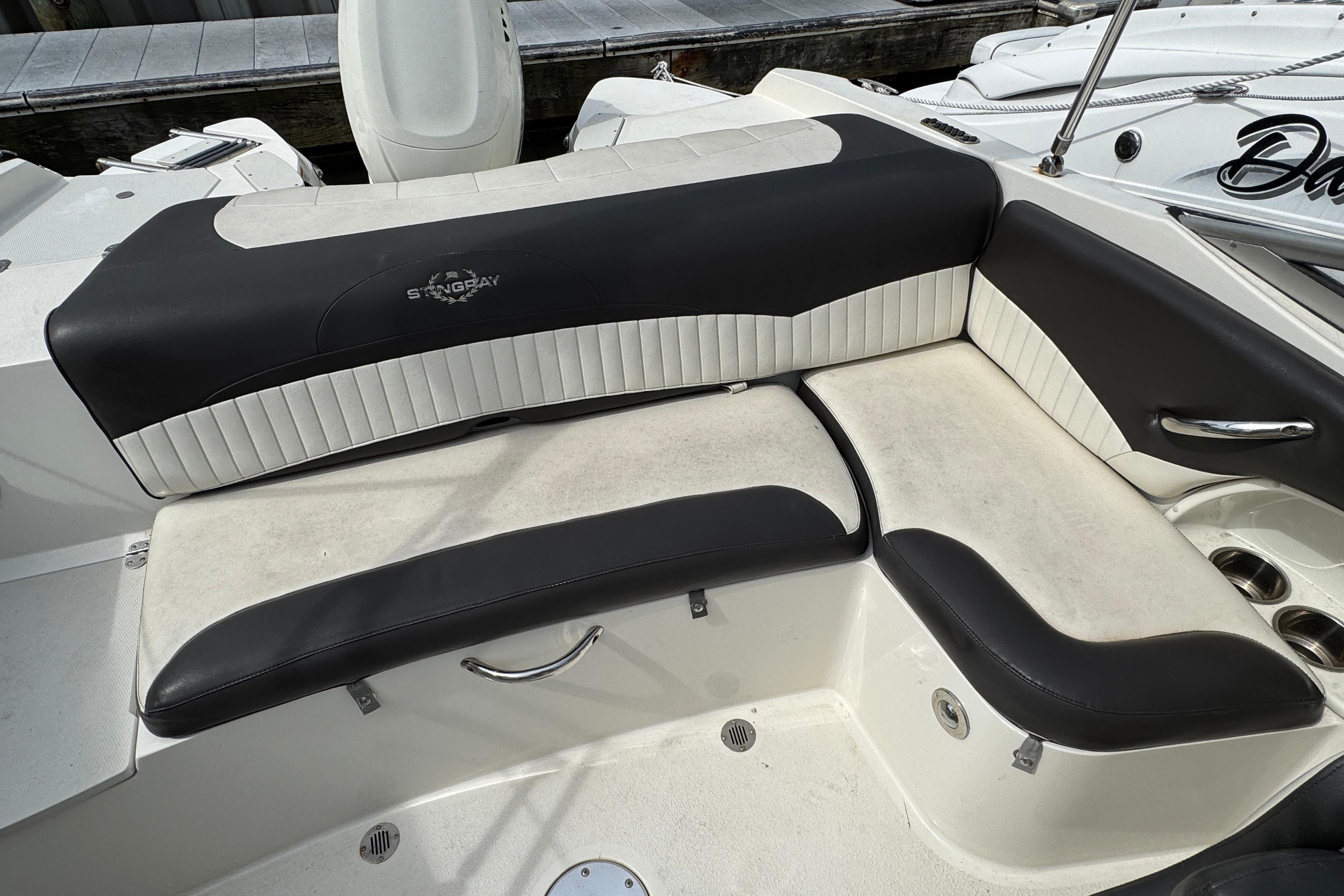 2018 Stingray 204 LR boat interior with black and white seating, docked at marina.