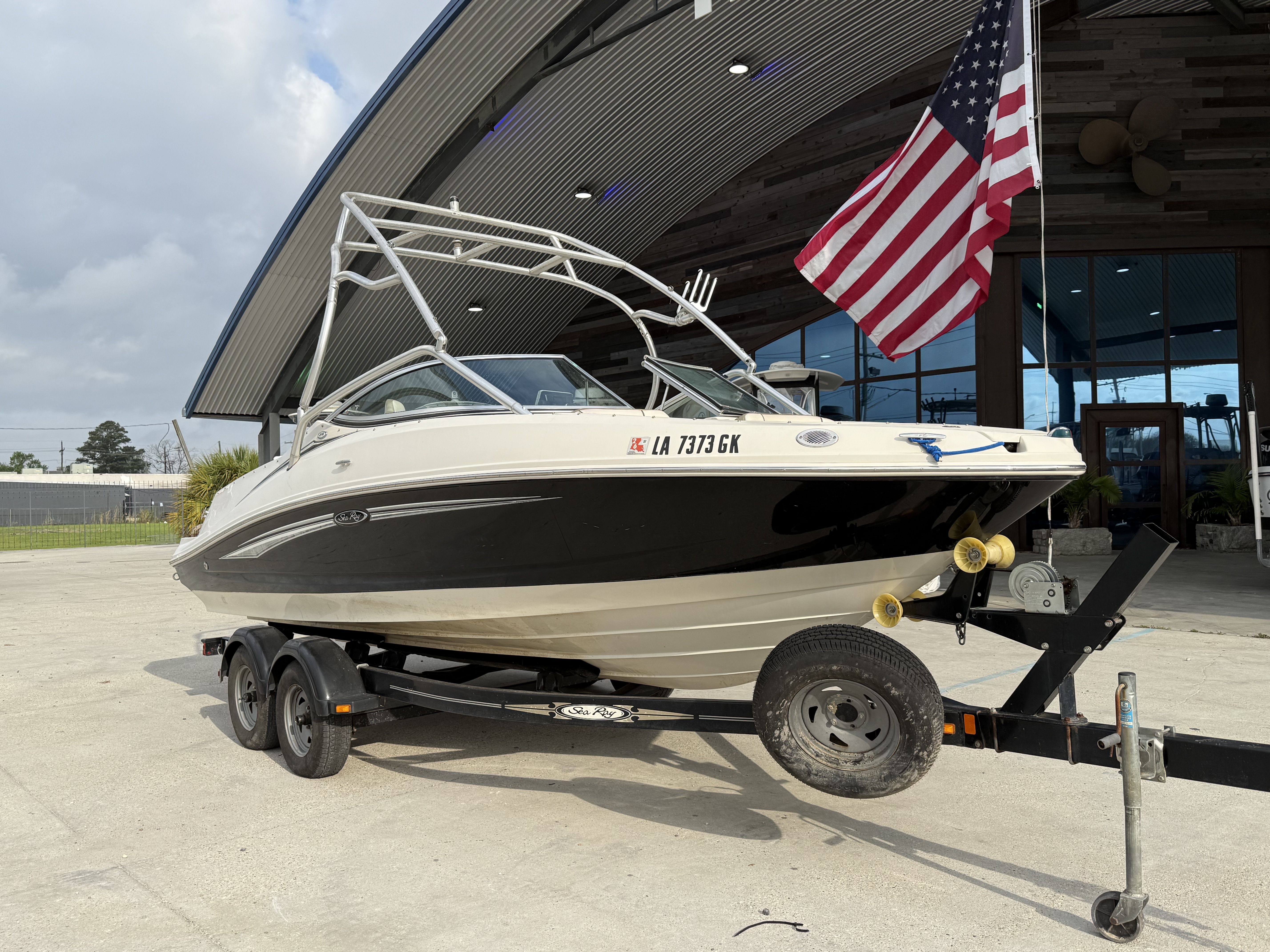 2007 Sea Ray 210 boat on trailer in front of building.
