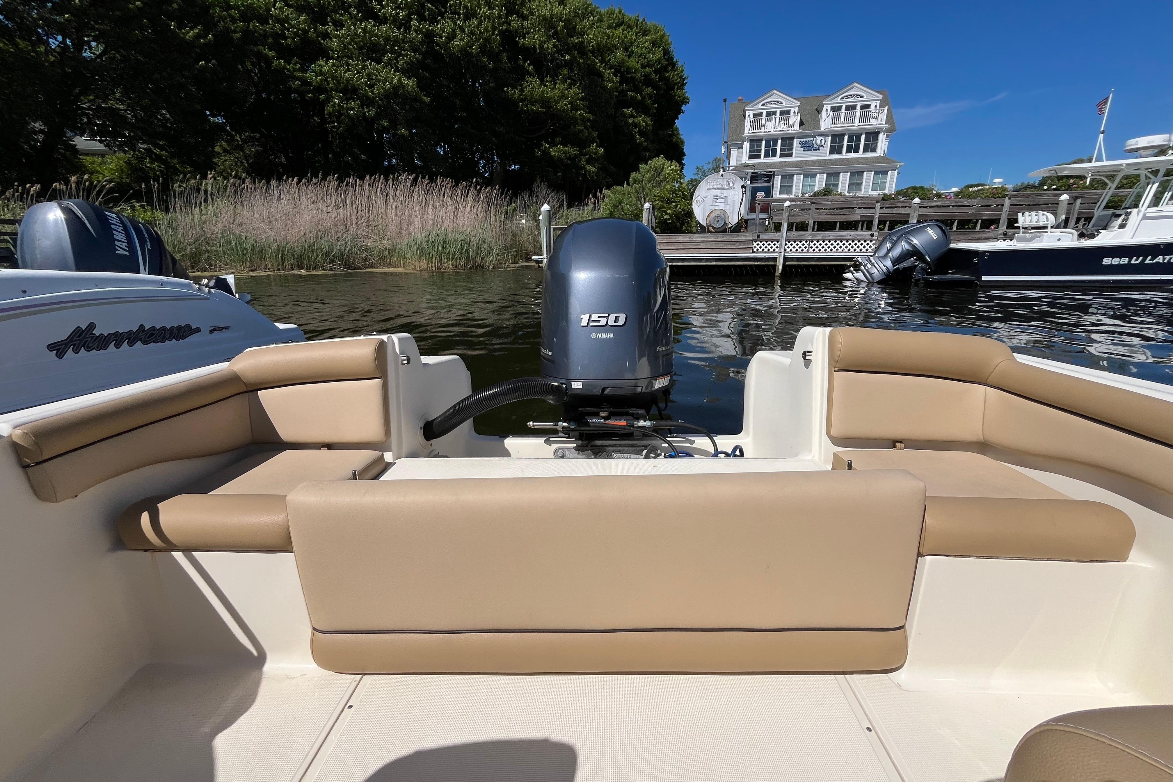 2017 Scout 210 Dorado boat with Yamaha 150 engine, docked near waterfront homes.