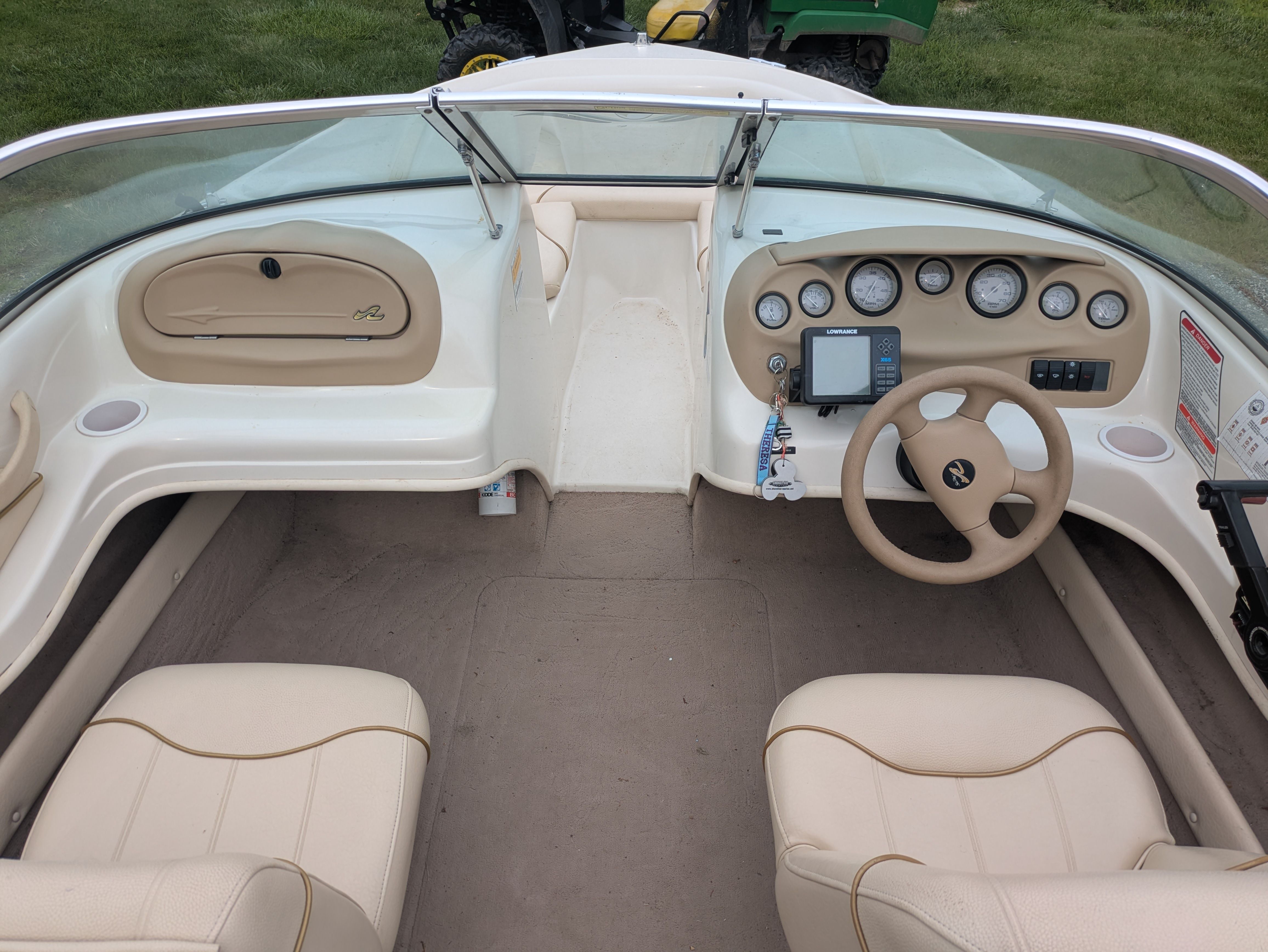 Interior view of a Sea Ray 185 Bow Rider boat with cream seats and dashboard.