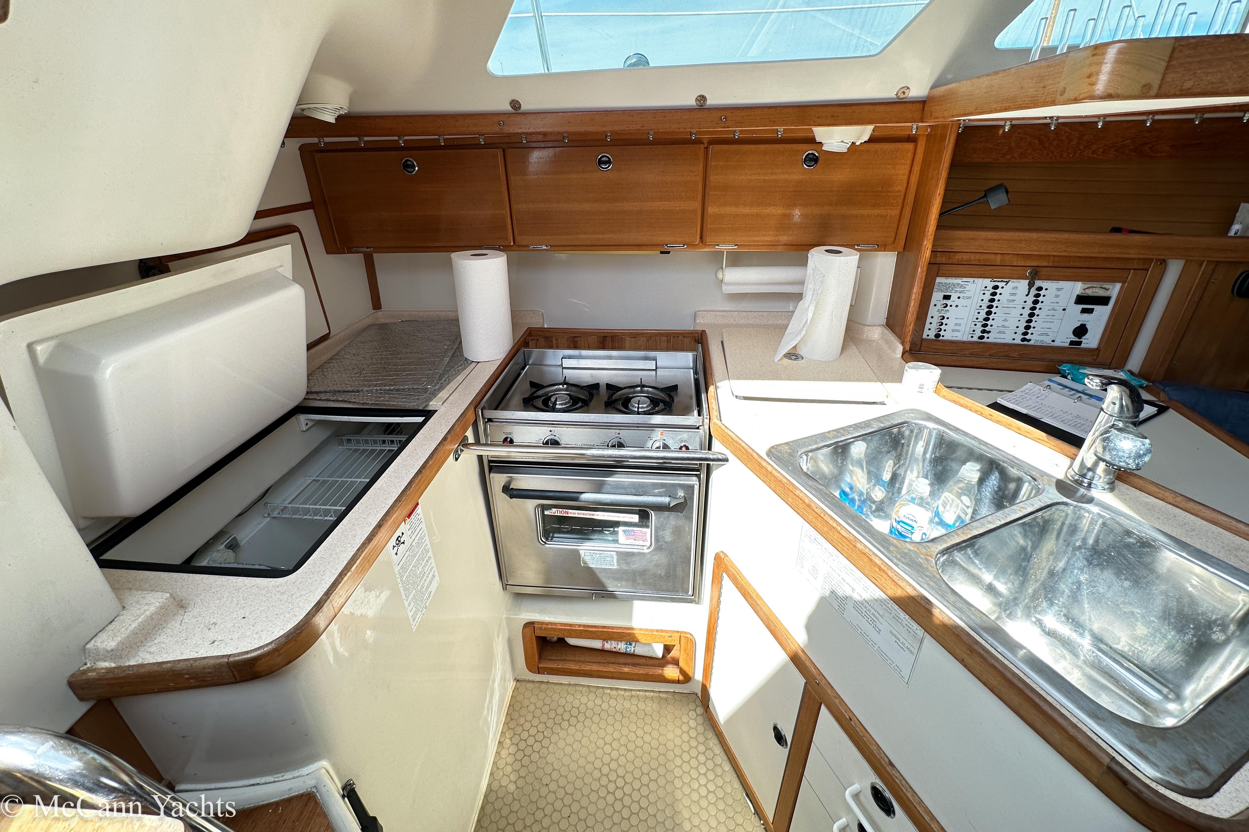 2003 Catalina 320 yacht kitchen with stove, sink, and storage cabinets.
