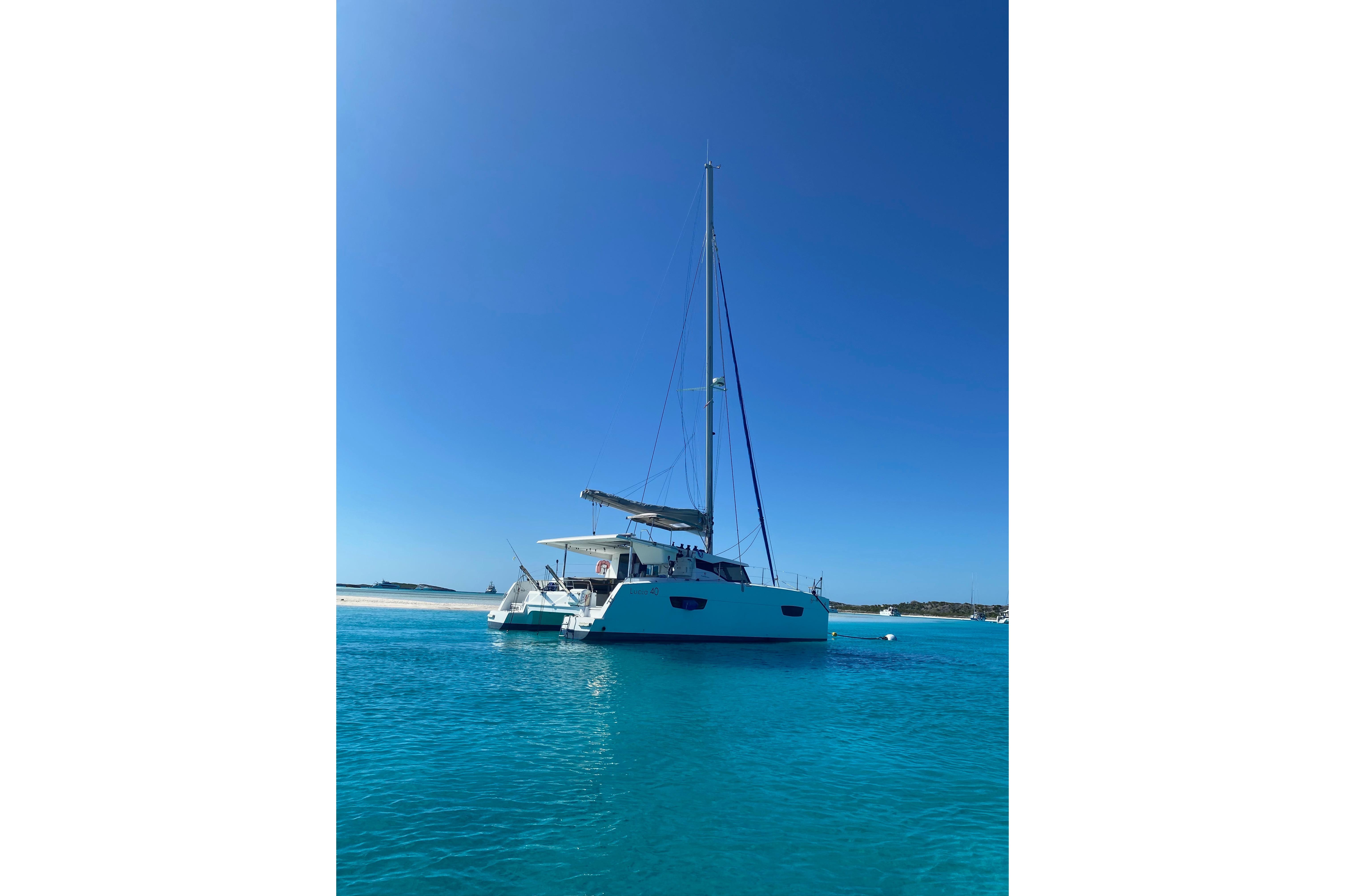 2018 Fountaine Pajot Lucia 40 catamaran sailing on clear blue waters.