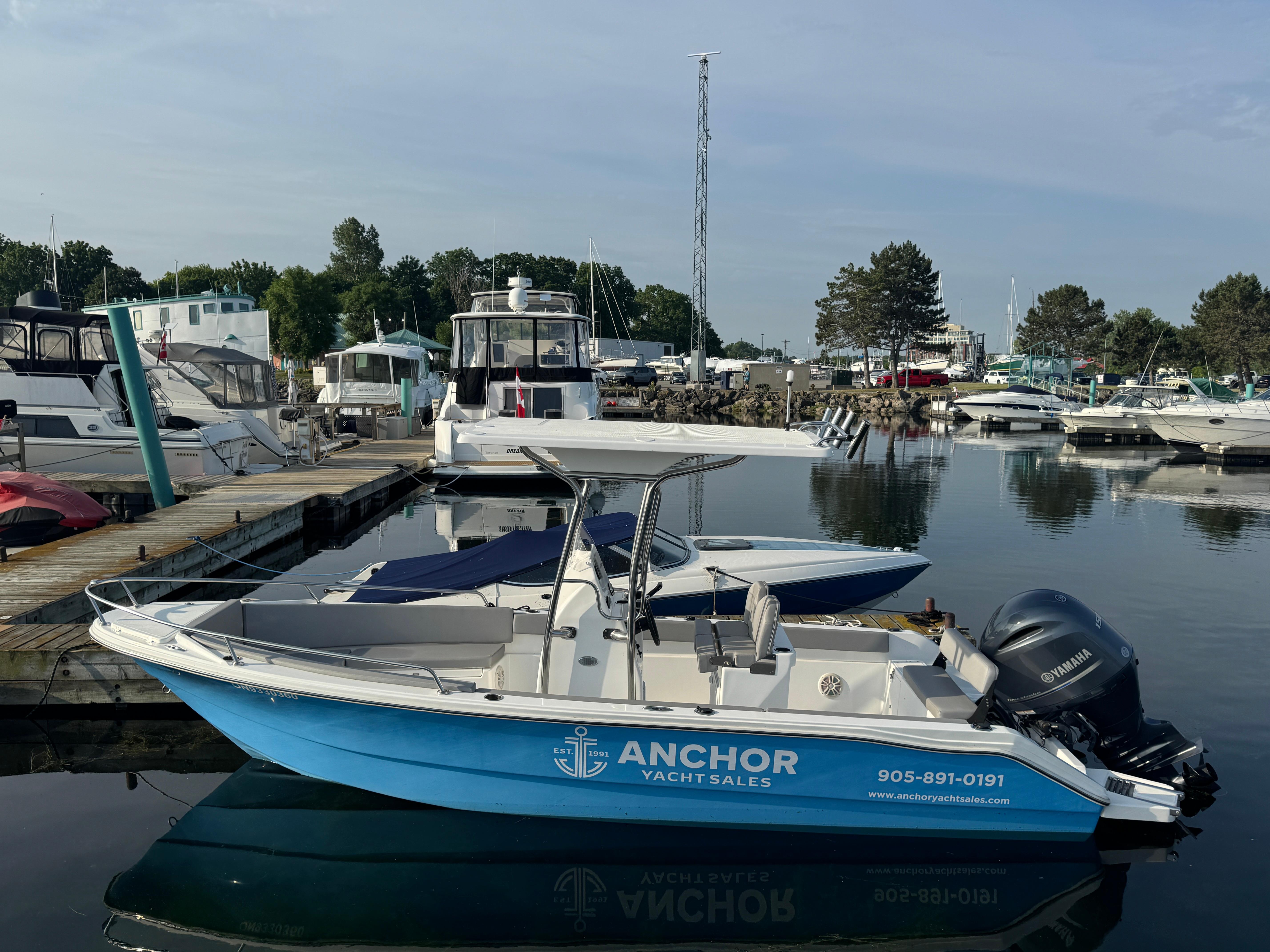 Apex 21 boat docked at marina, 2023 model, with Anchor Yacht Sales branding.