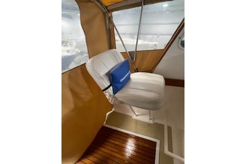 1964 Striker Model 120 boat interior with white seat and wooden flooring.