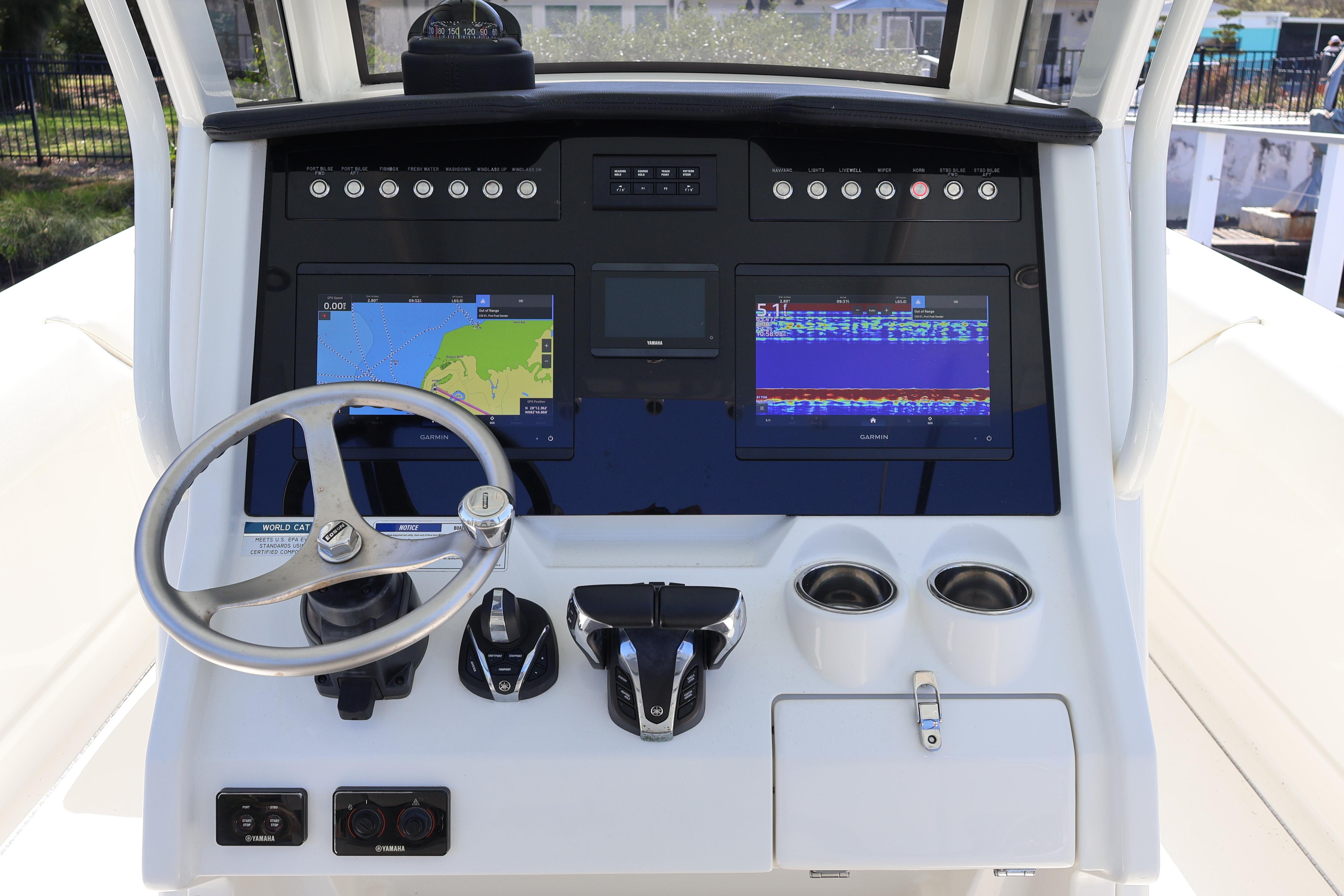2022 World Cat 280 CC-X boat dashboard with navigation screens and steering wheel.