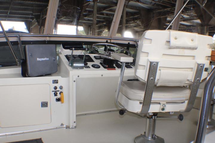 1988 Tollycraft 30 Sport Cruiser helm with captain's chair and navigation controls.