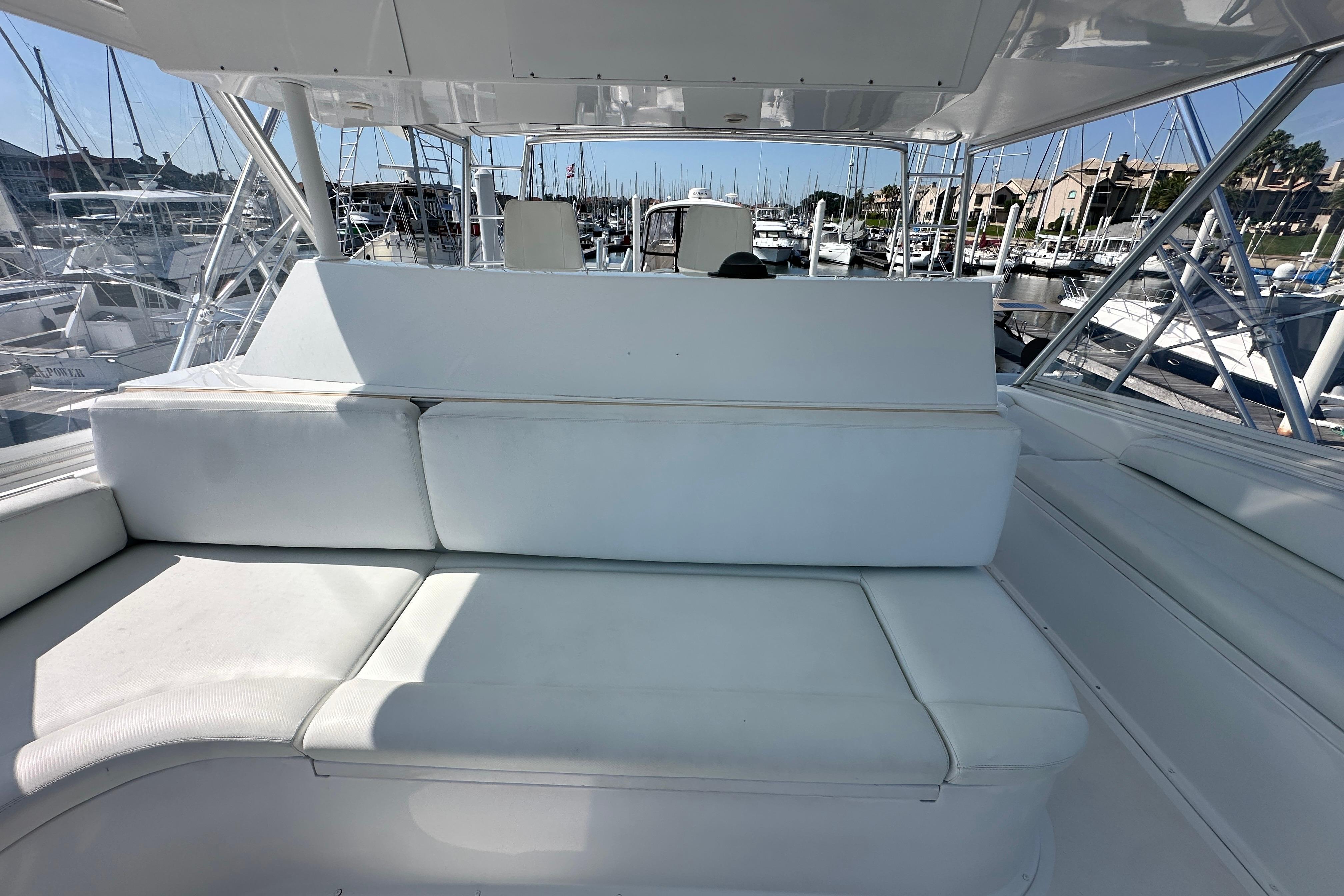 White seating area on a 1997 Viking 58 Convertible yacht, docked at a marina.