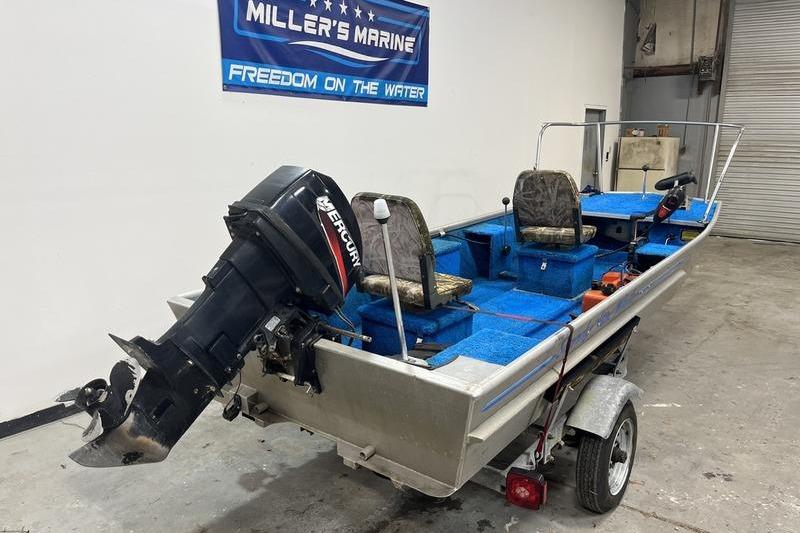 2006 SCANDY WHITE 1310 boat with Mercury outboard motor on trailer in garage.