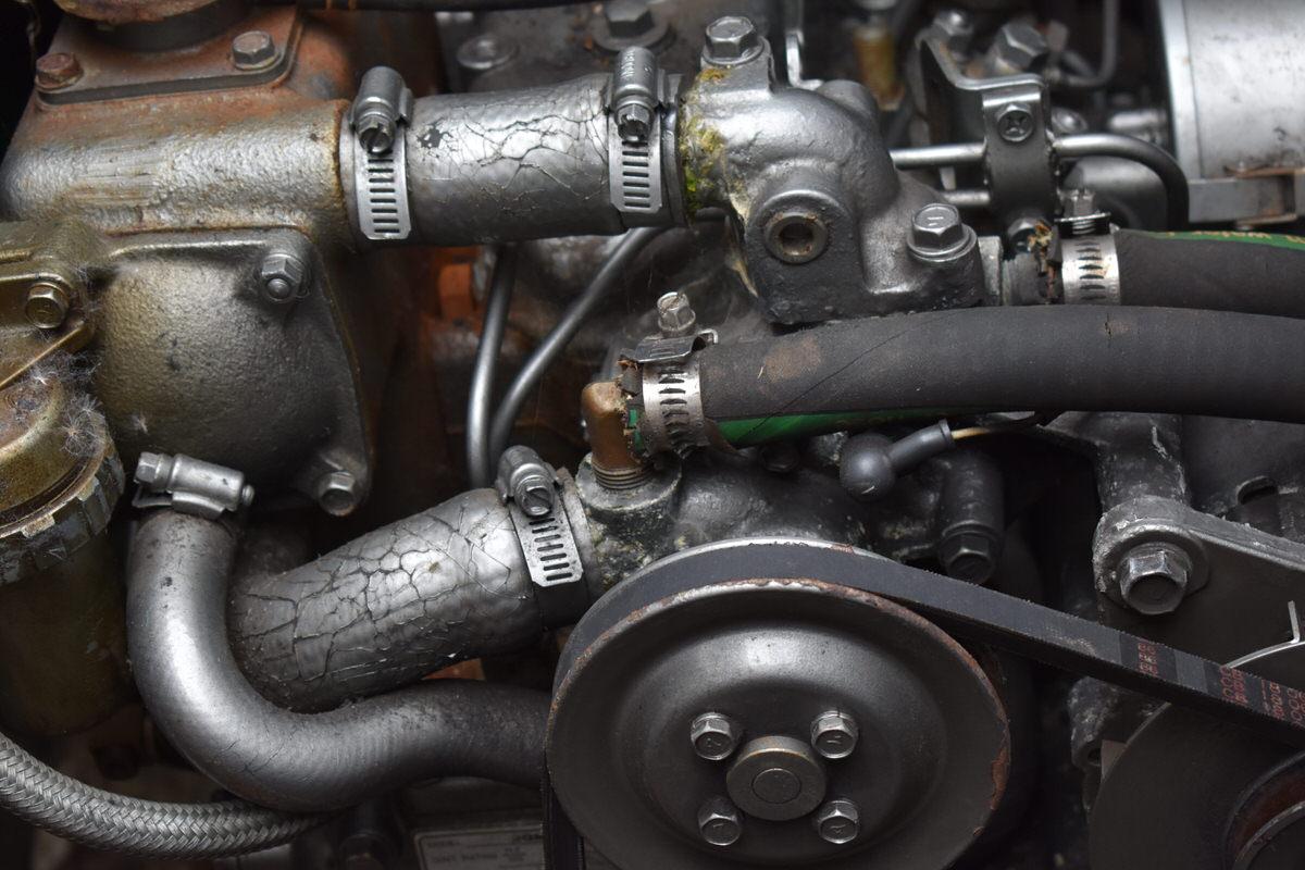Close-up of a boat engine with hoses and metal components.