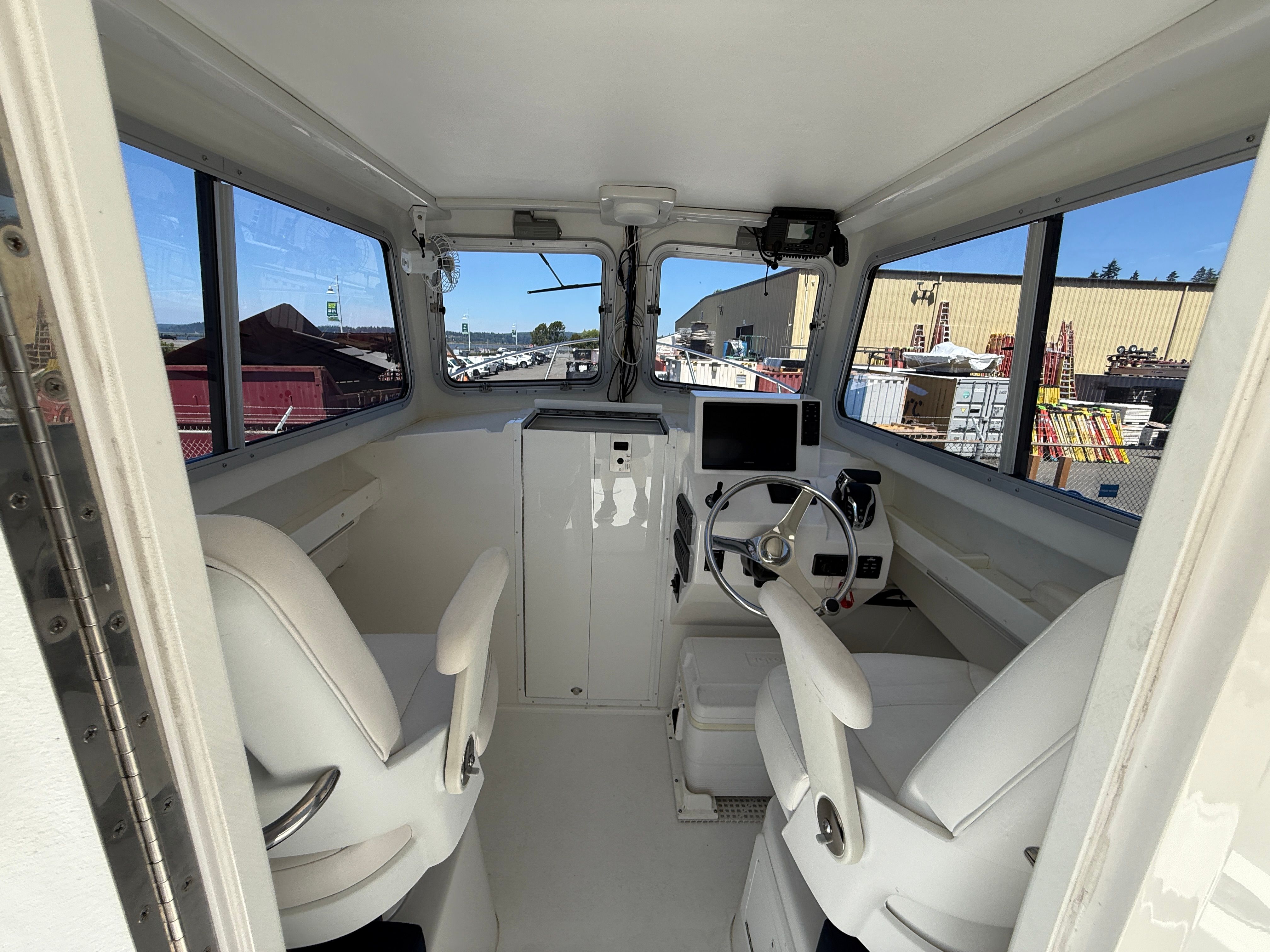 Interior view of the 2015 Steiger Craft 255 Chesapeake with two seats and a helm console.
