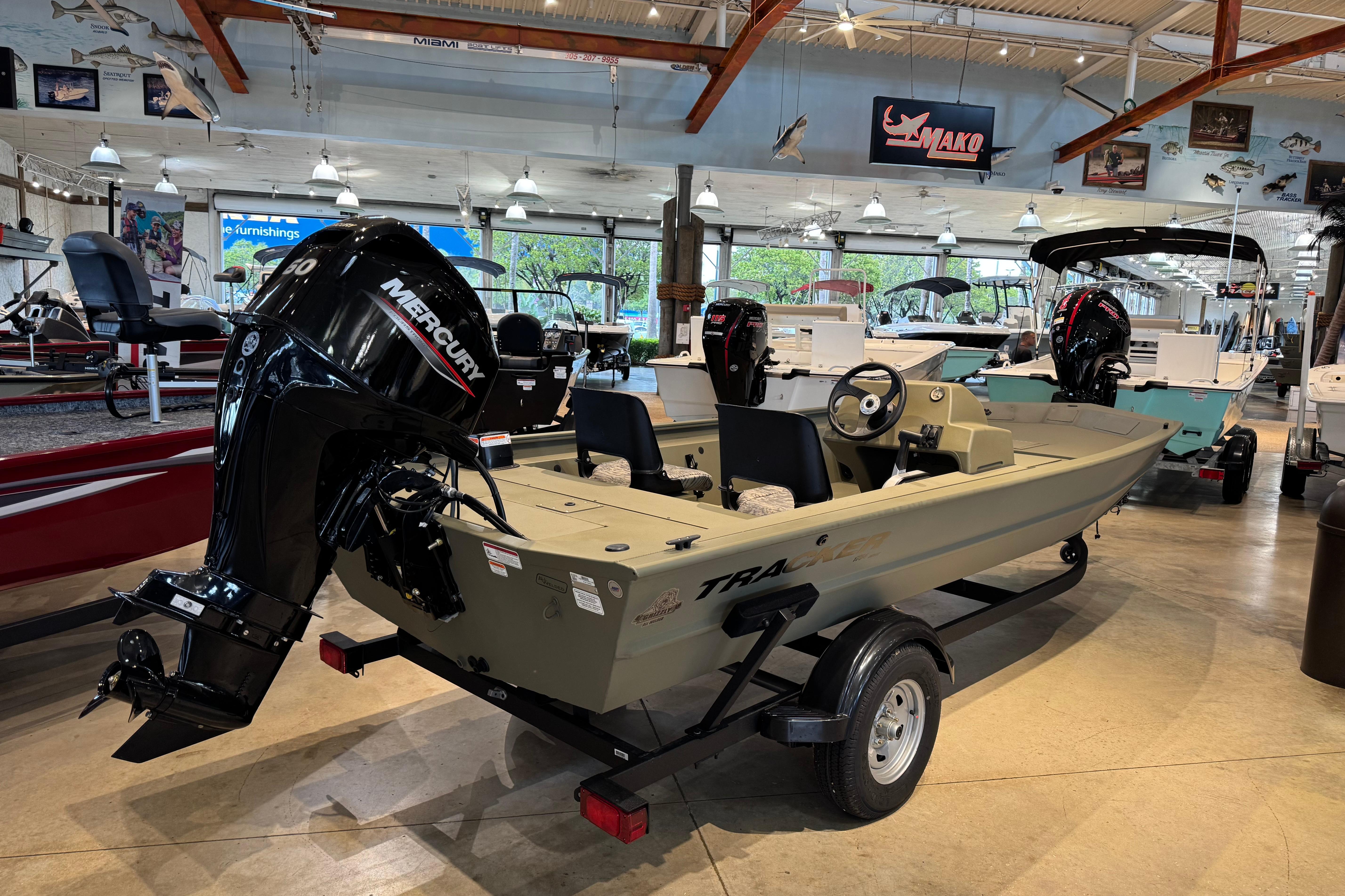 2026 Tracker Grizzly 1754 SC boat displayed in a showroom with Mercury engine.