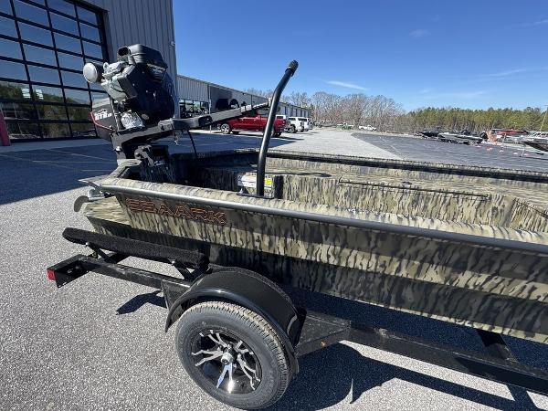 2025 SeaArk 1752 Slayer Pro boat on trailer, camo design, parked outdoors.