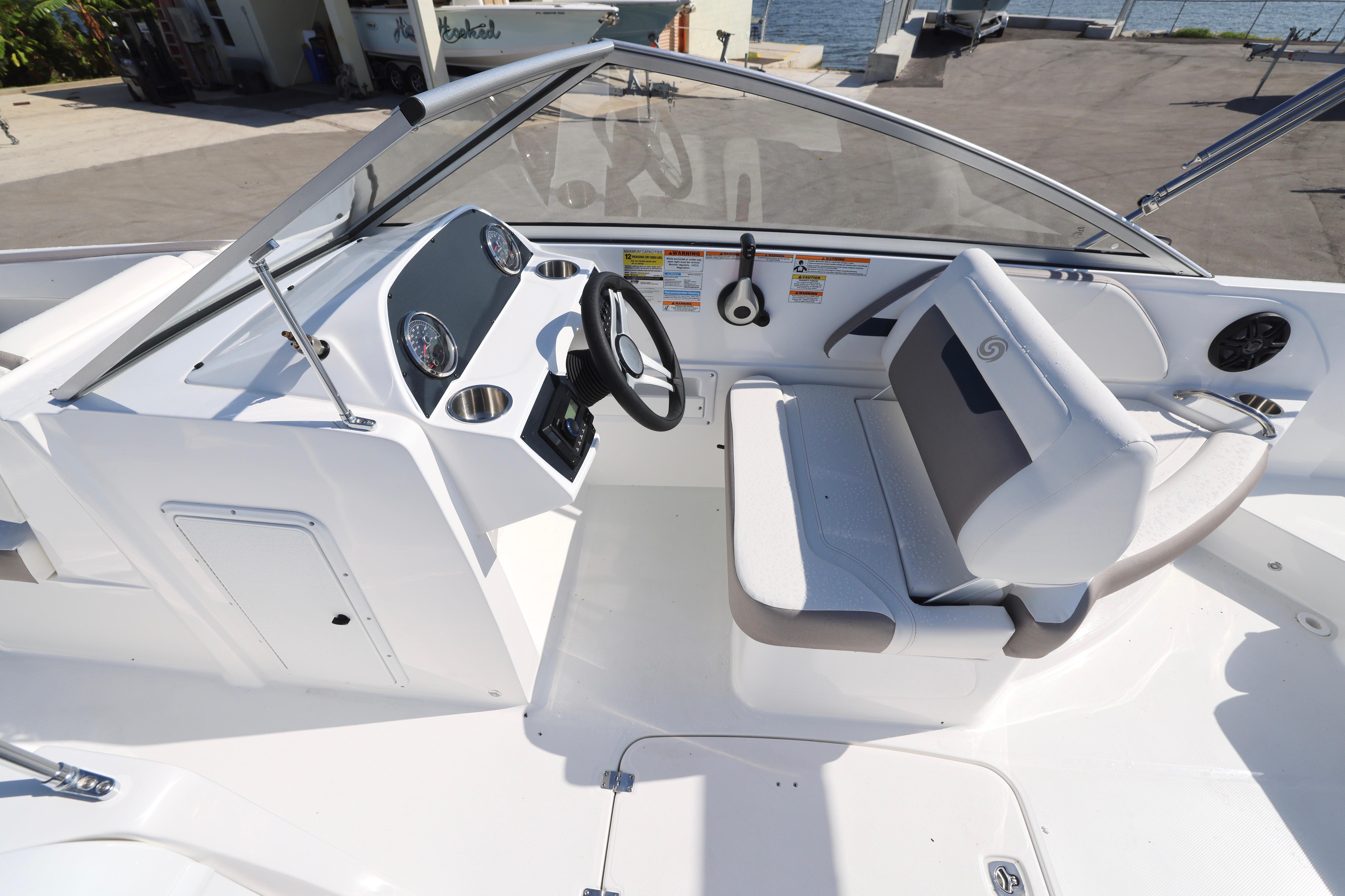 2026 Hurricane SunDeck 235 OB boat interior with steering console and seating.
