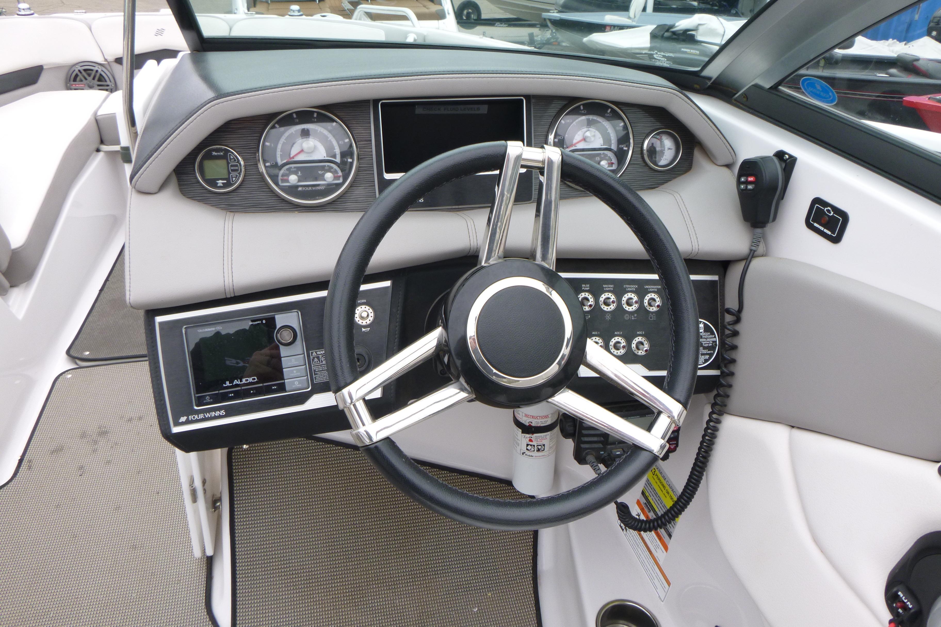 2017 Four Winns H260 boat dashboard with steering wheel and control panel.