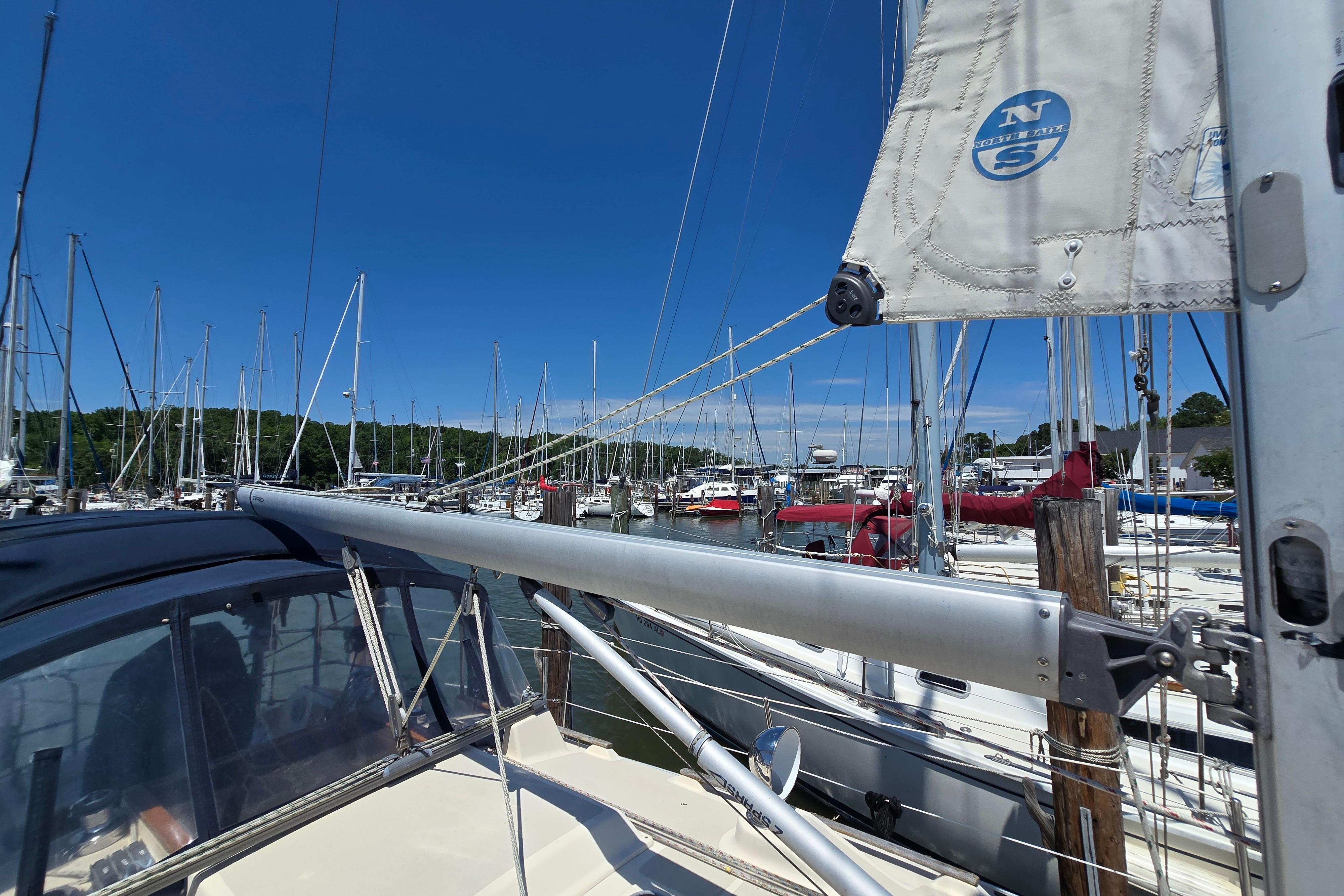 Sailboats docked at a marina under clear blue skies, featuring a 1993 Caliber 35.