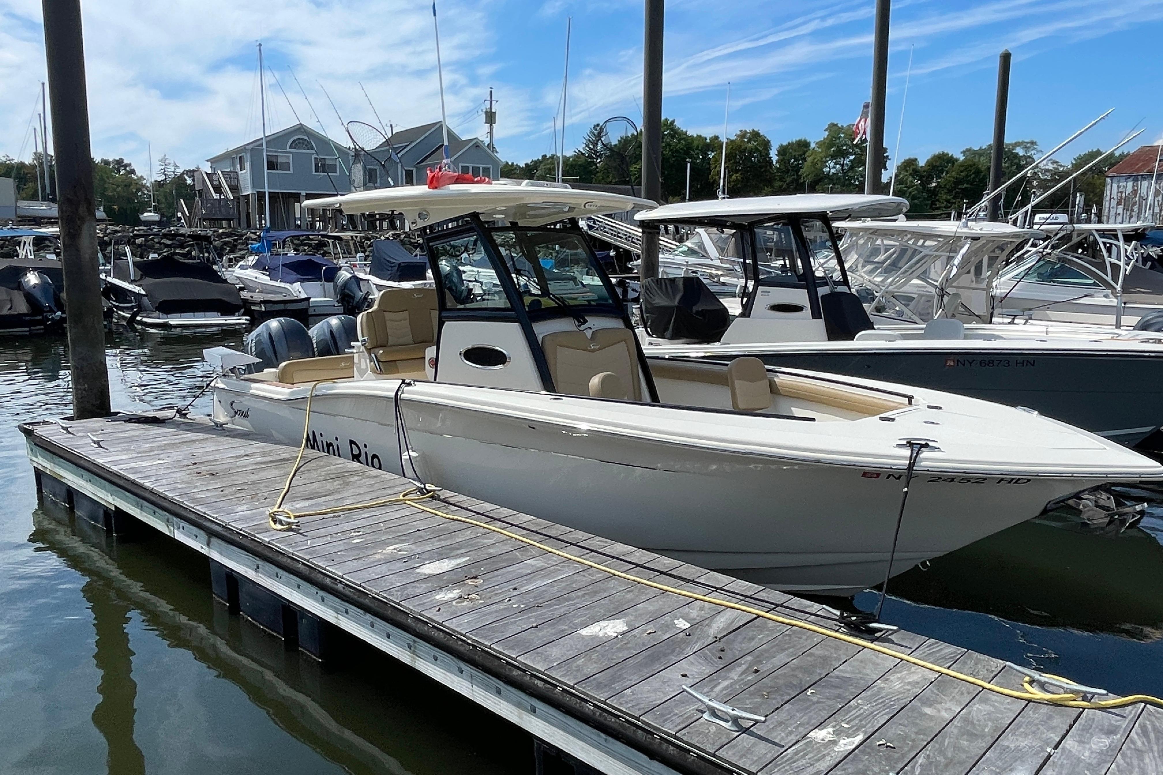 2020 Scout 255 LXF boat docked at a marina, surrounded by other vessels.