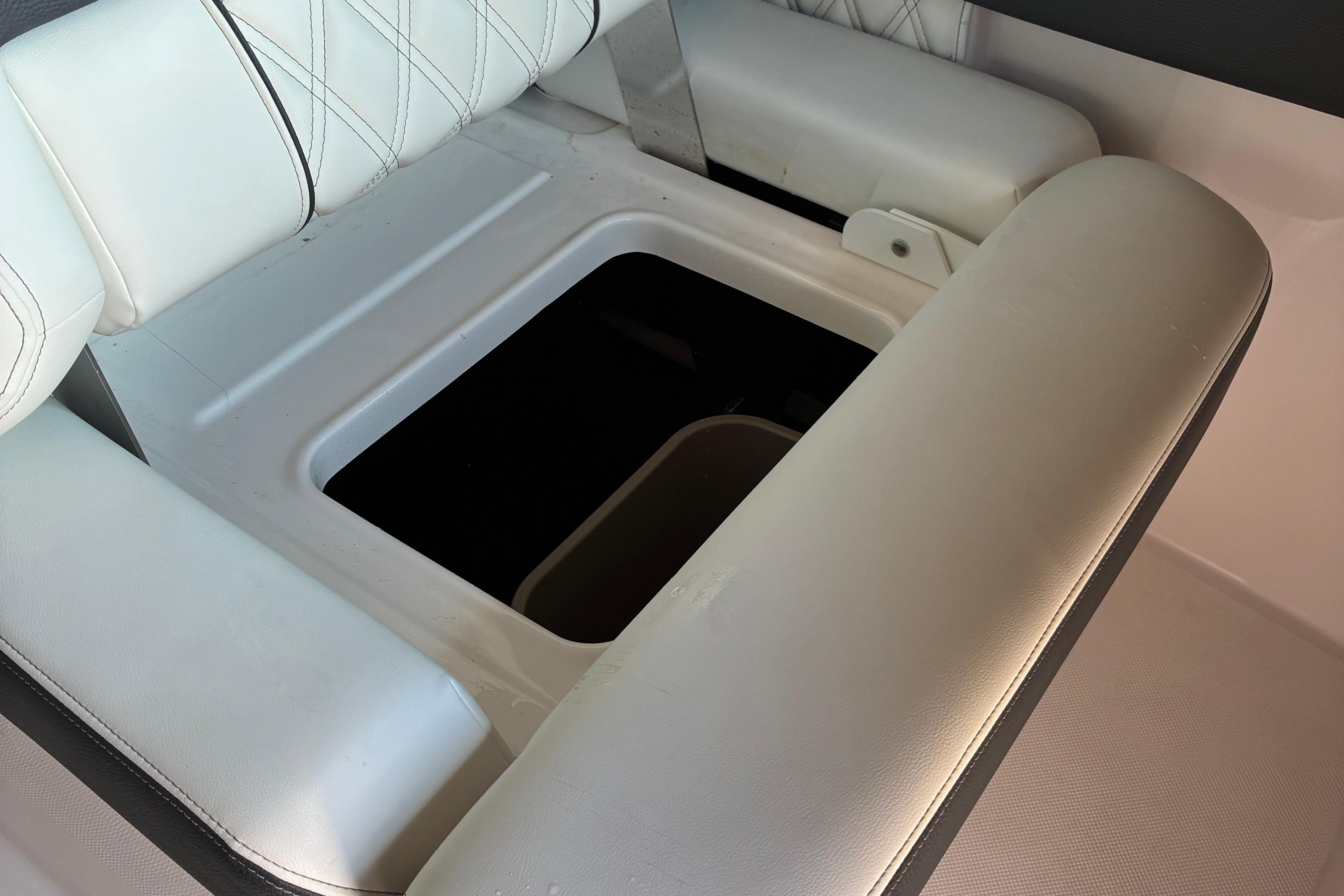 2025 Regal LS2 boat interior with open storage compartment under white cushioned seating.