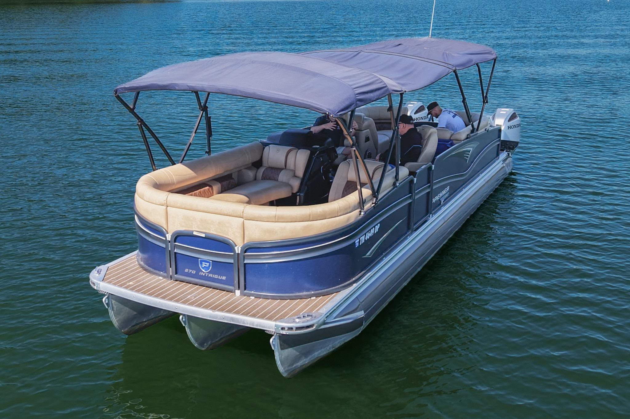 2023 Premier 270 Intrigue RF pontoon boat cruising on a serene lake.