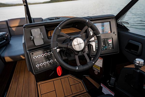 Manufacturer Provided Image: 2025 Moomba Mojo boat dashboard with steering wheel and control panel on a lake.