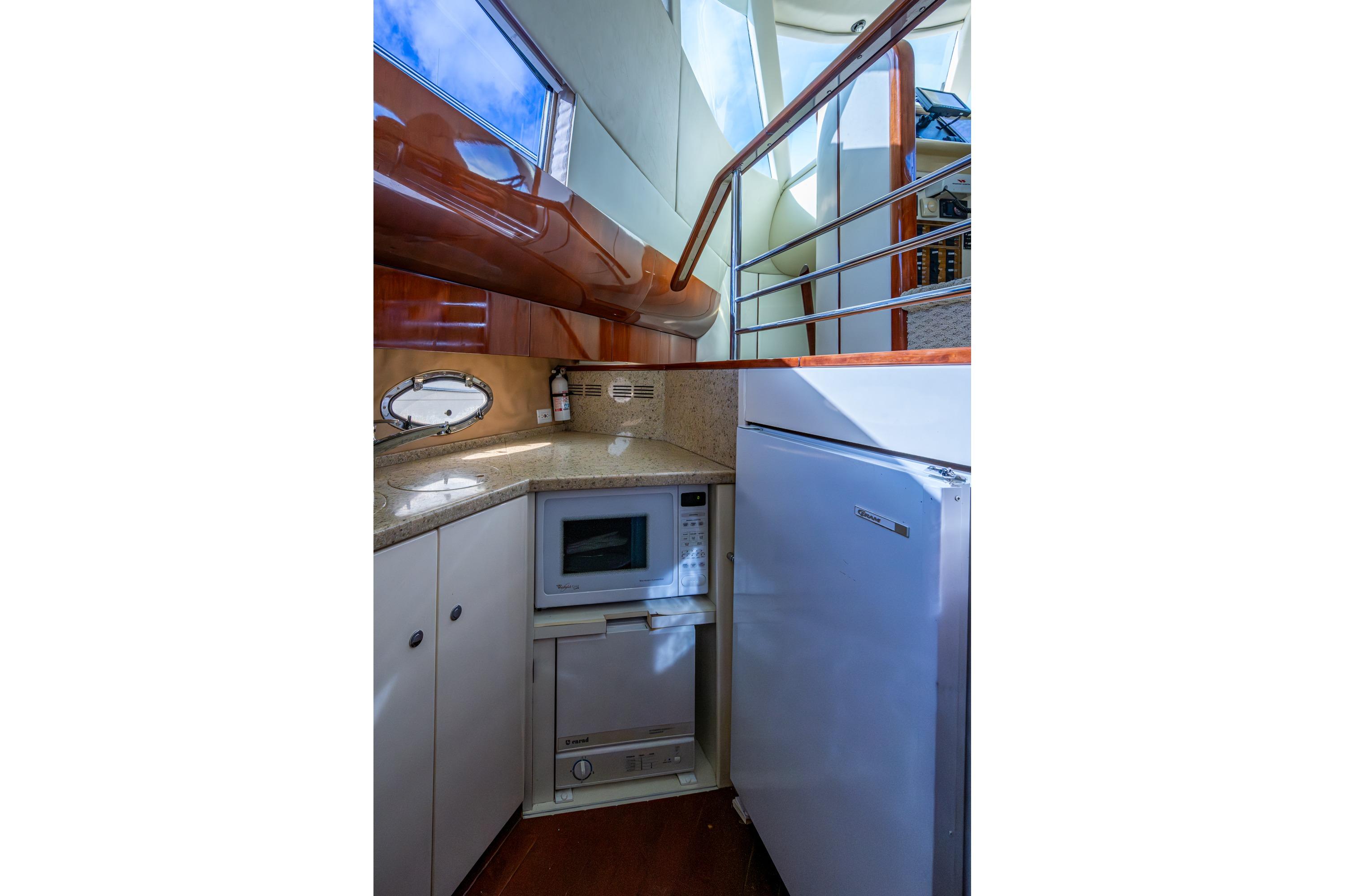 Compact kitchen area in a 2000 Fairline Squadron 52 yacht, featuring modern appliances.