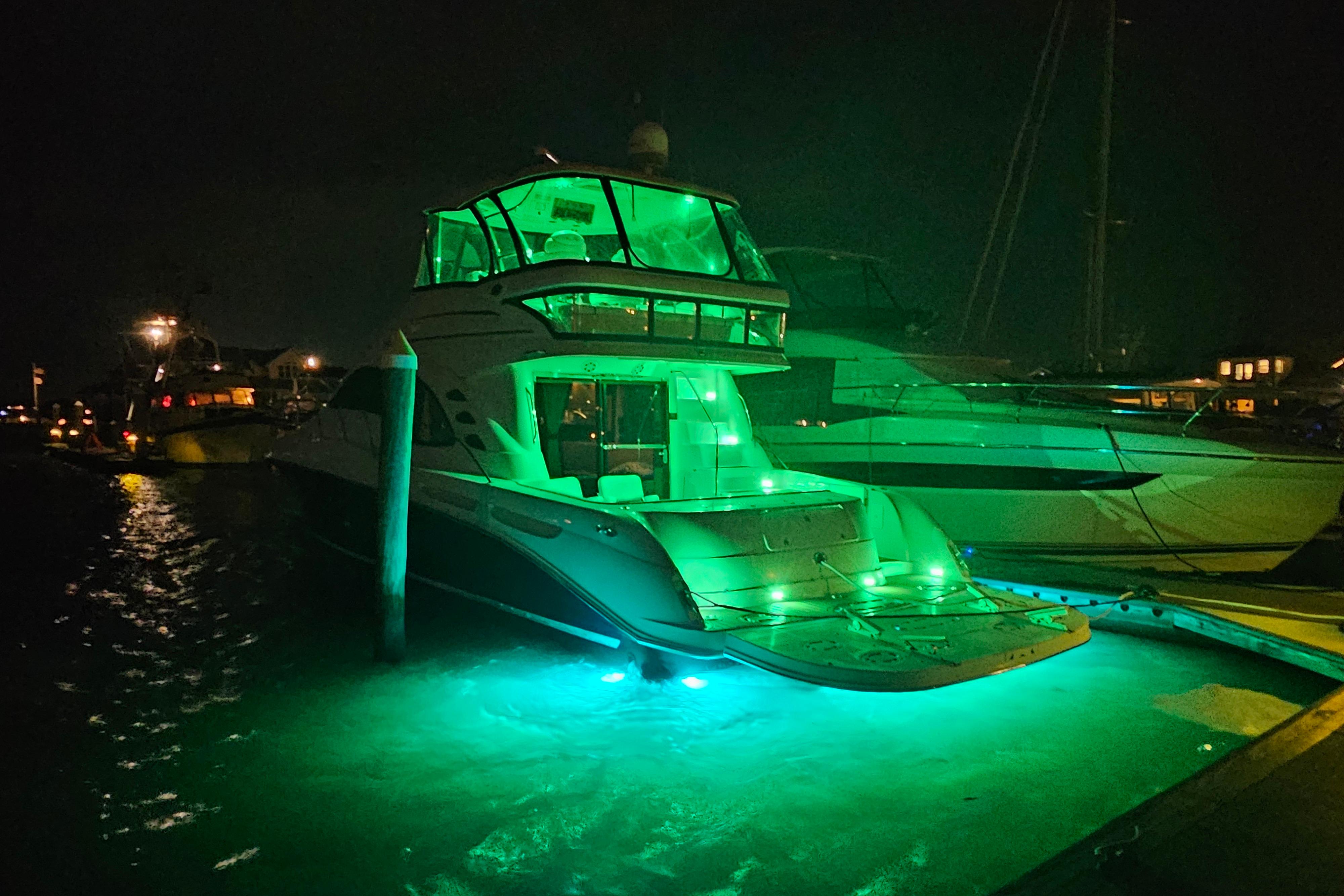 2006 Sea Ray 580 Sedan Bridge yacht illuminated with green lights at night.