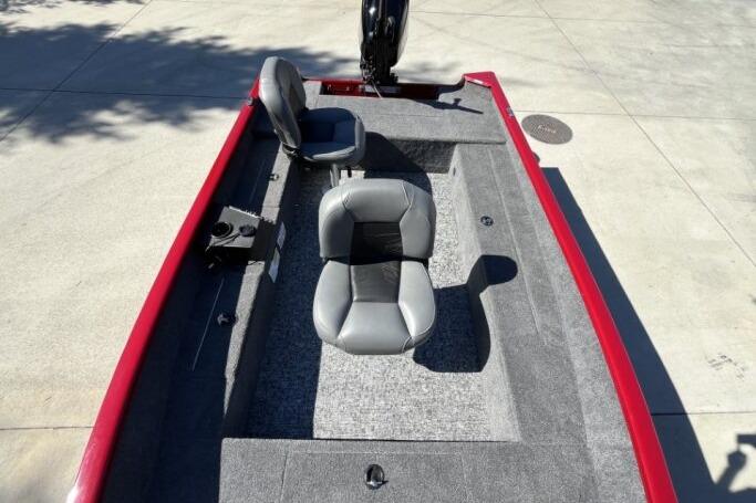 2025 Tracker Super Guide V-16 T boat interior with gray seats and red trim.
