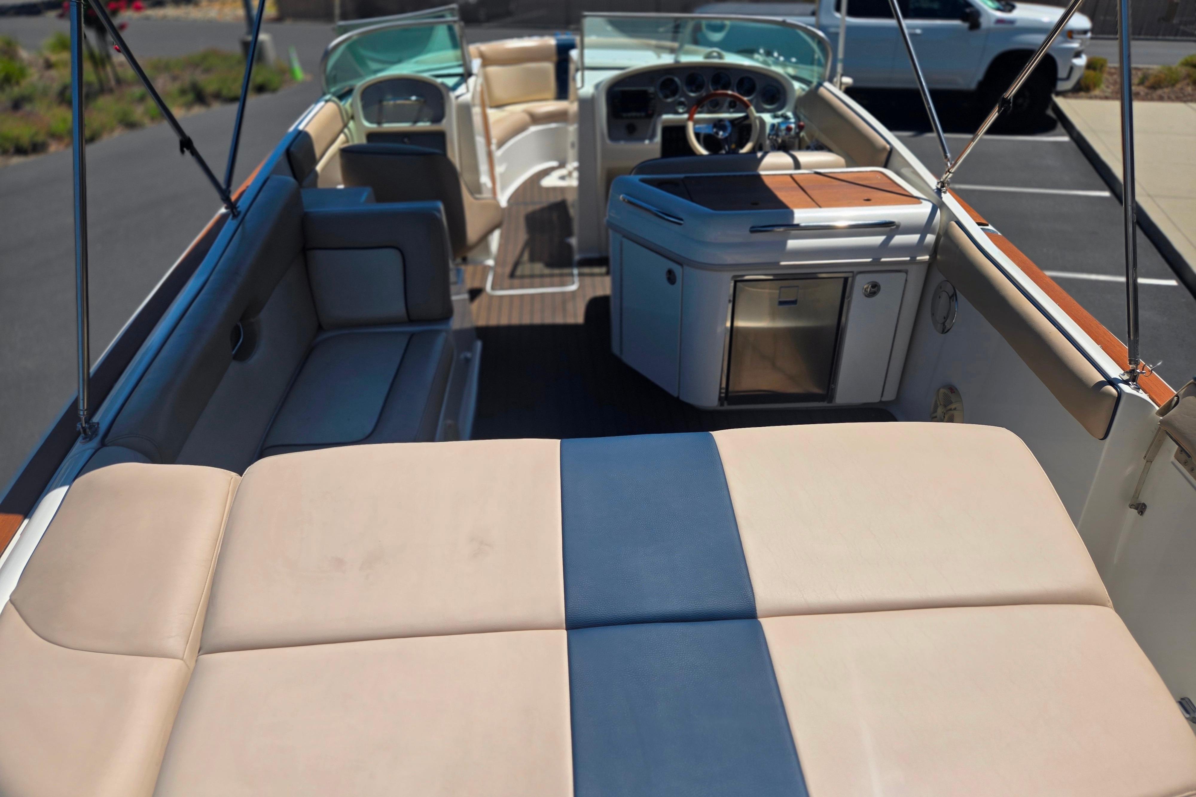 2002 Chris-Craft Launch 28 GT I/O boat interior with seating and helm, parked in a lot.