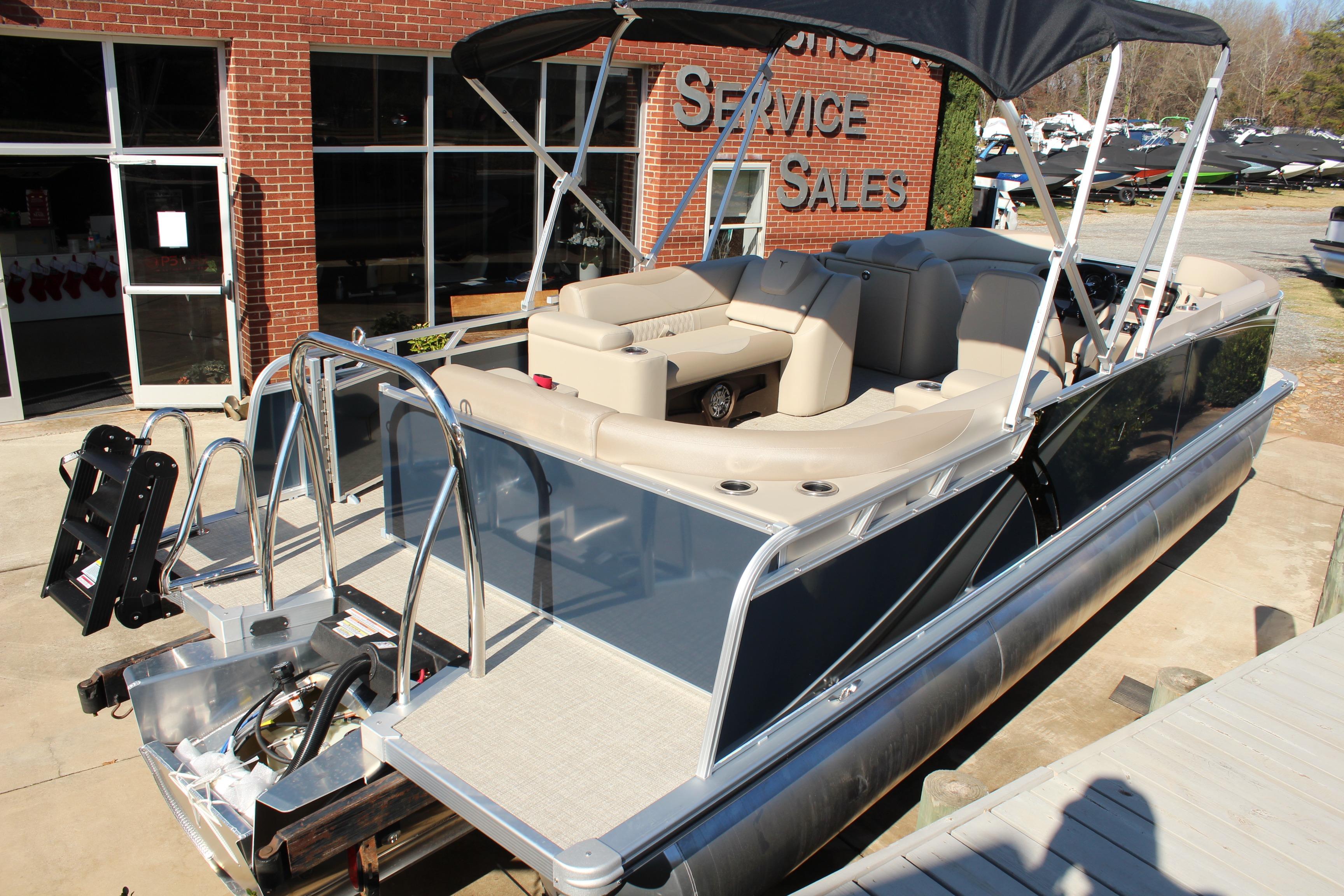 2026 Tahoe Pontoon LTZ Elite boat with canopy, parked outside a sales building.