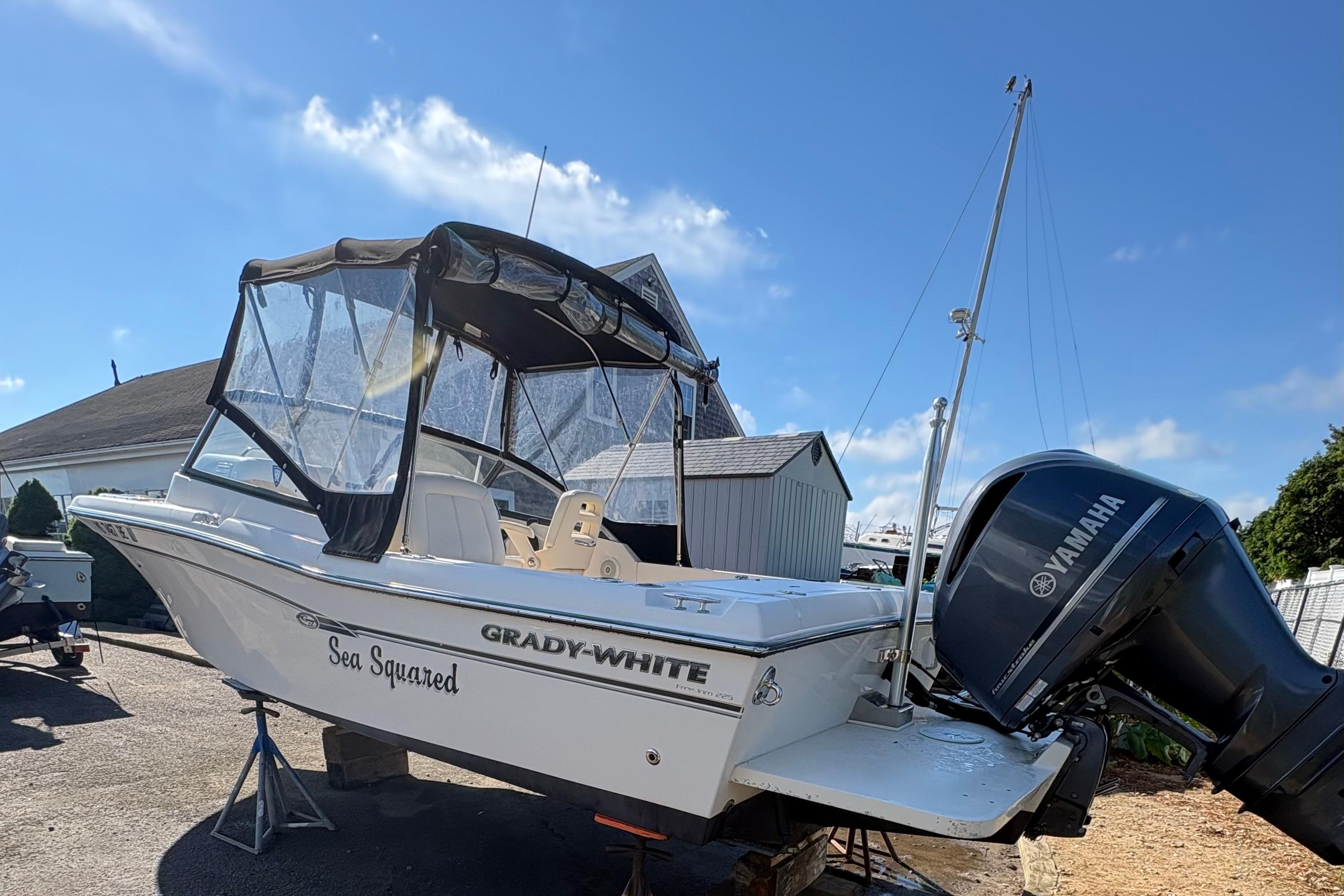 2015 Grady-White Freedom 225 boat with Yamaha engine, docked under clear blue sky.