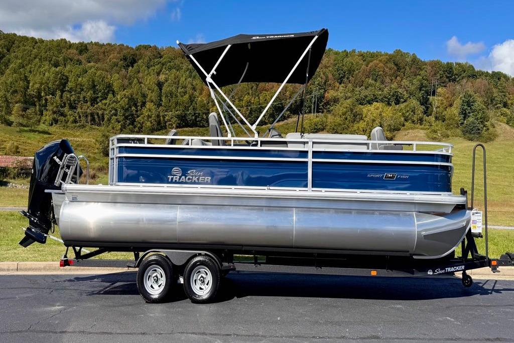 2026 Sun Tracker Sportfish 24 XP3 pontoon boat on trailer, scenic background.