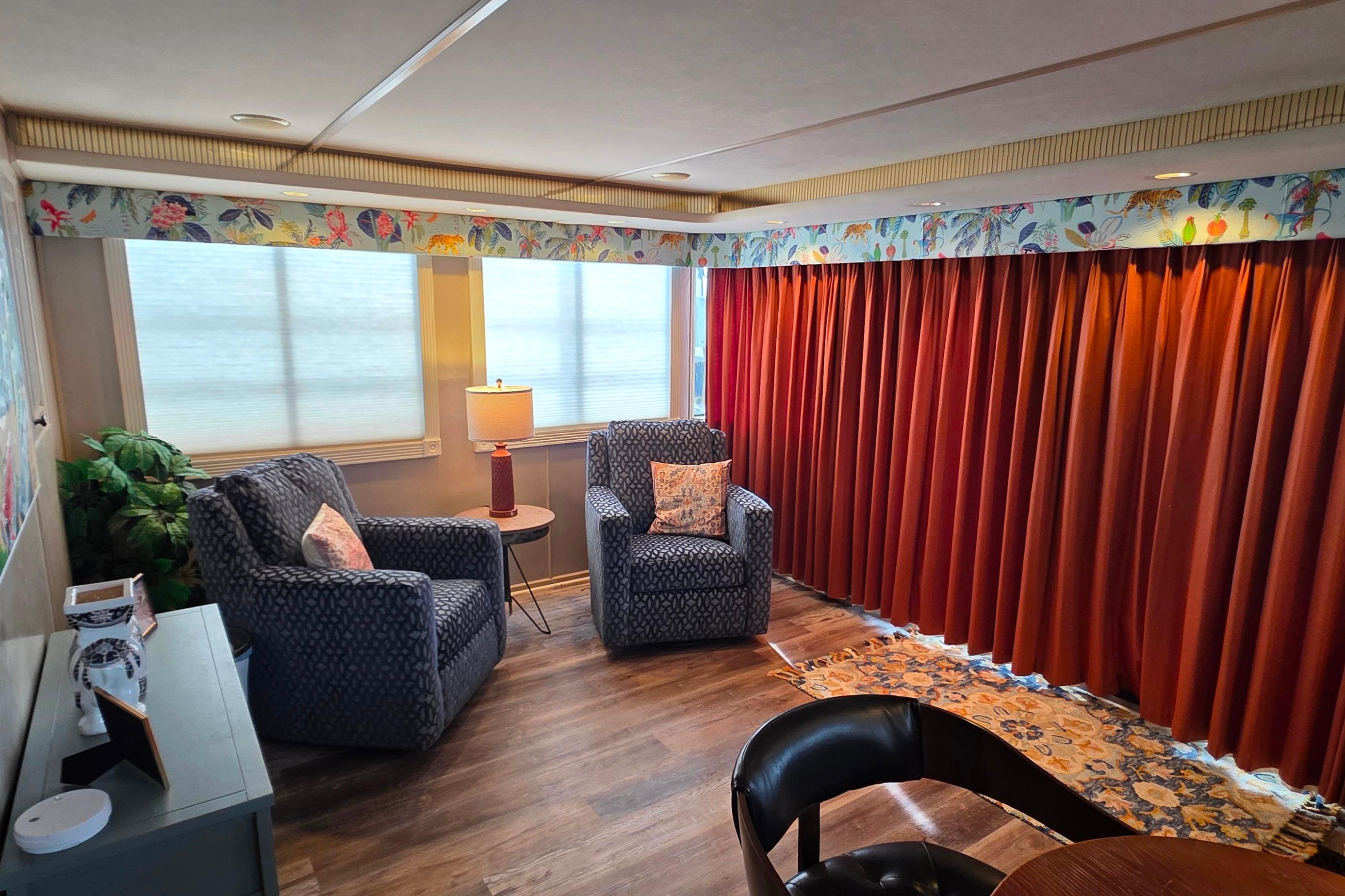 Cozy living area in 1999 Stardust Cruisers 16x60 houseboat with armchairs and vibrant decor.