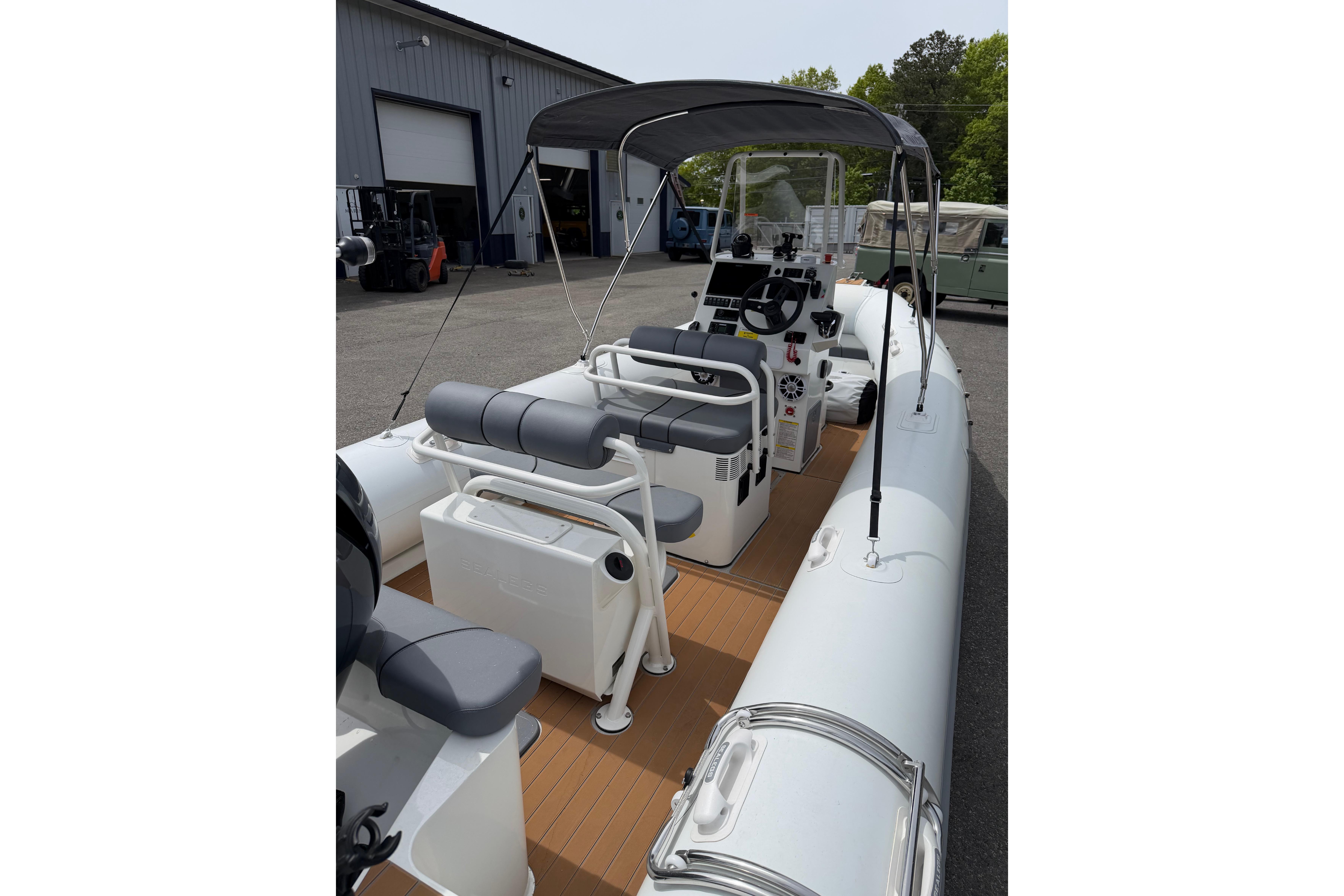 2024 Sealegs 7.1m RIB with canopy, parked near a warehouse.