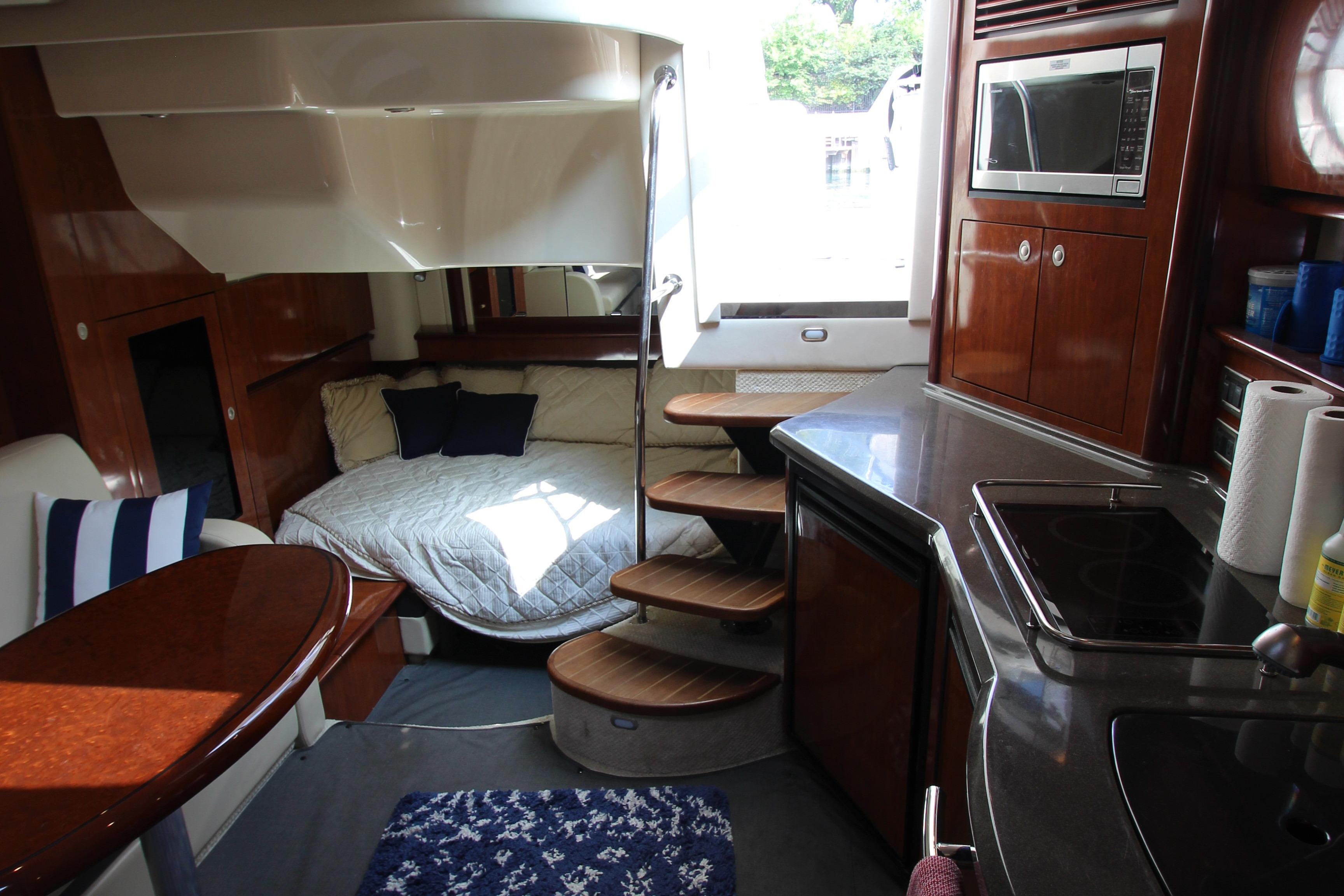 Luxurious interior of 2004 Sea Ray 40 Sundancer yacht with cozy bed and modern kitchen.