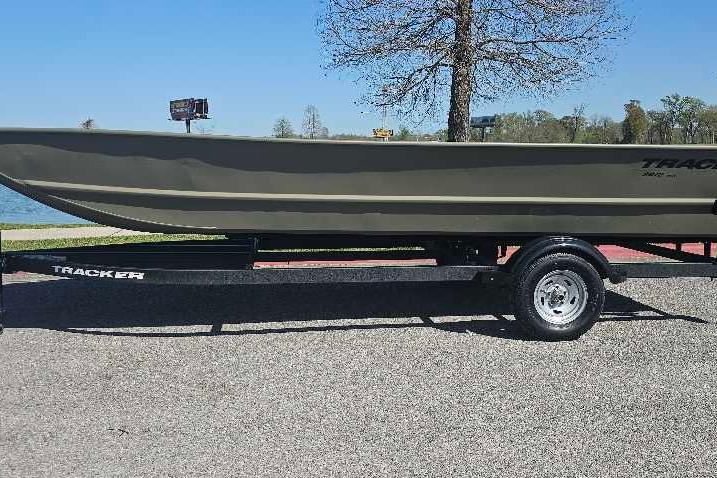 2025 Tracker Grizzly 2072 Utility boat on trailer, parked near a lake.