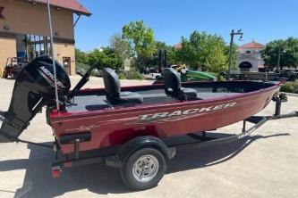 2025 Tracker Super Guide V-16 T boat on trailer, parked outdoors.
