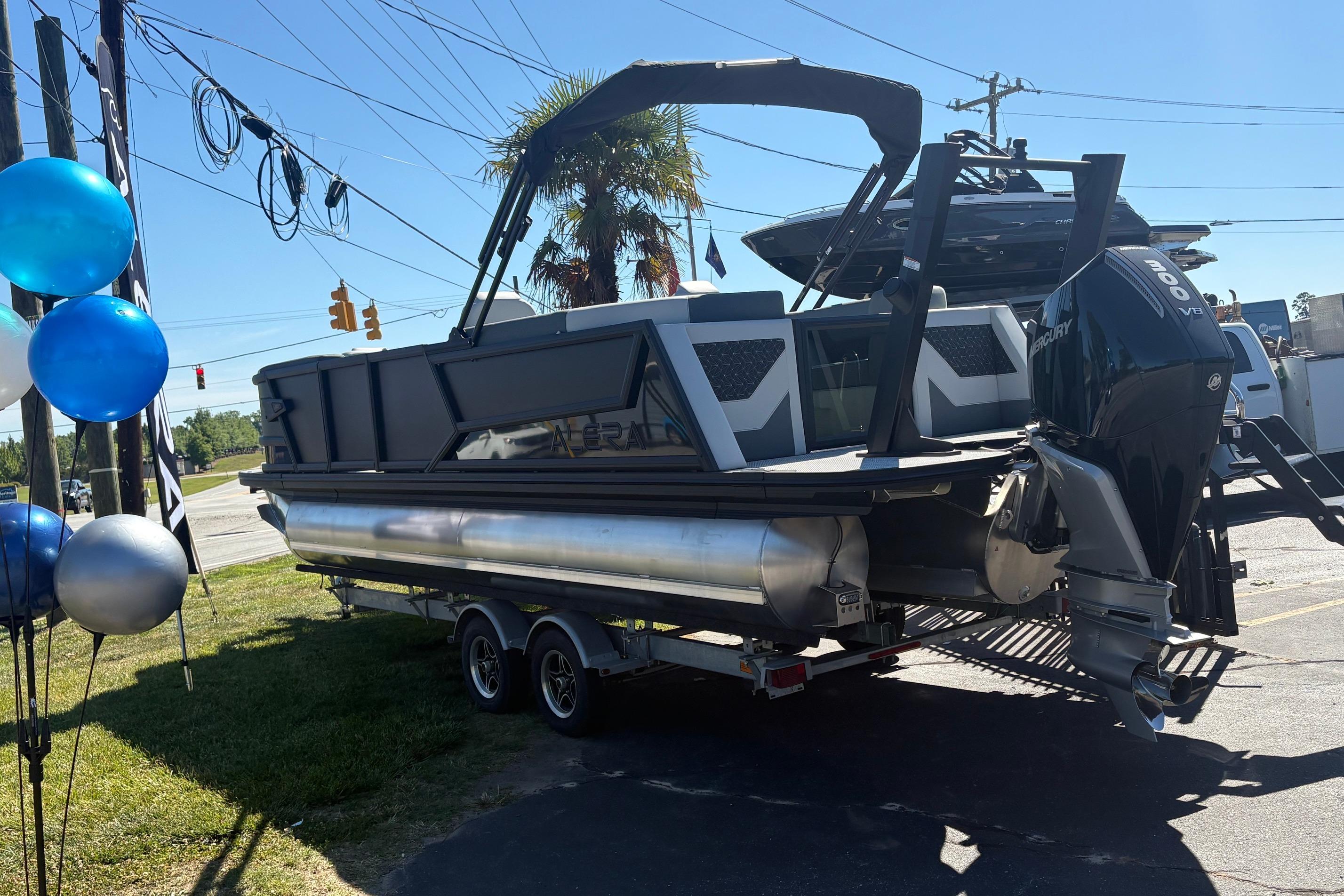 2026 Alera 23Q pontoon boat on trailer, displayed outdoors with balloons.