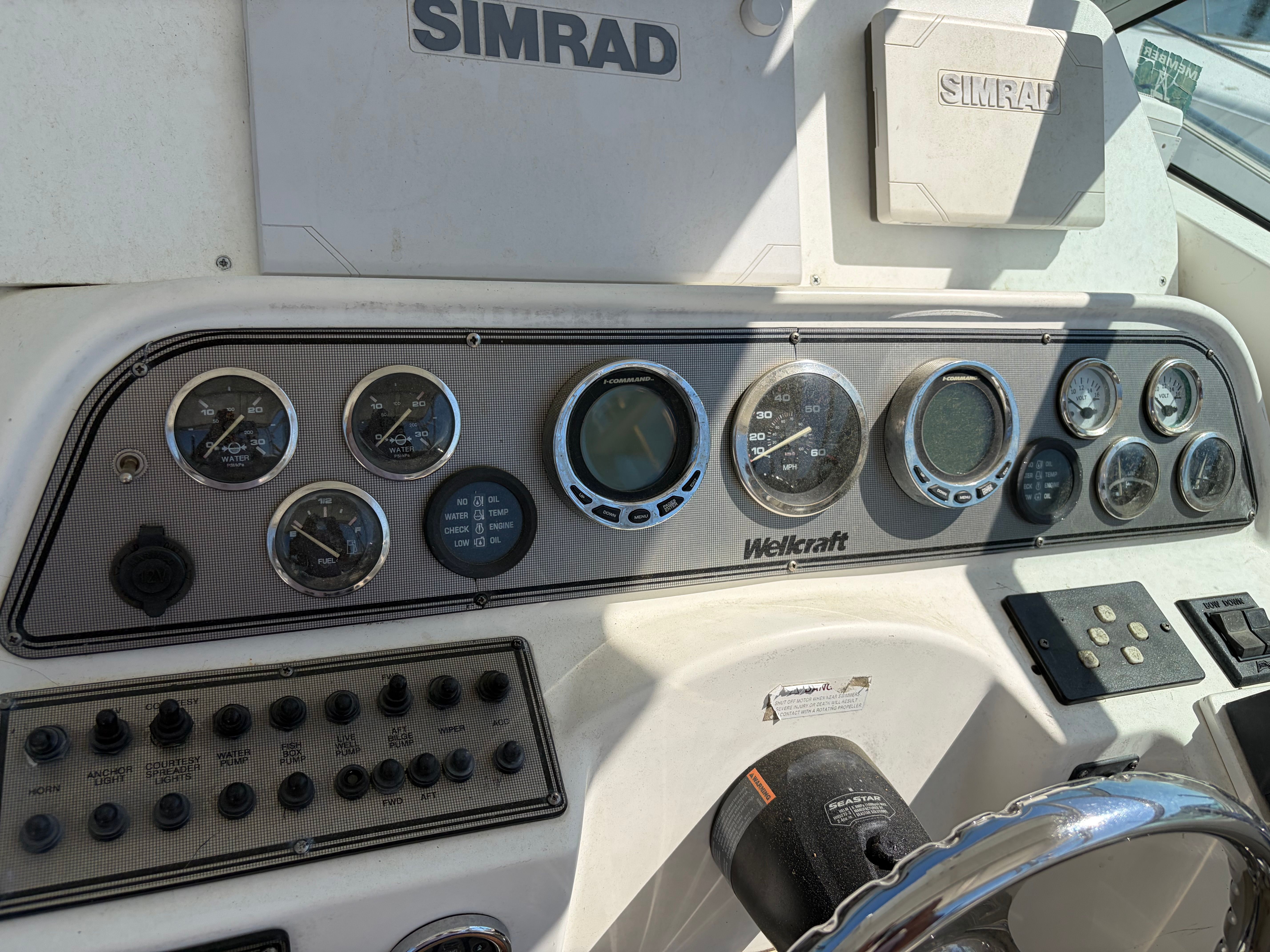 The image shows the dashboard of a 2000 Wellcraft 290 Coastal with various gauges and switches.
