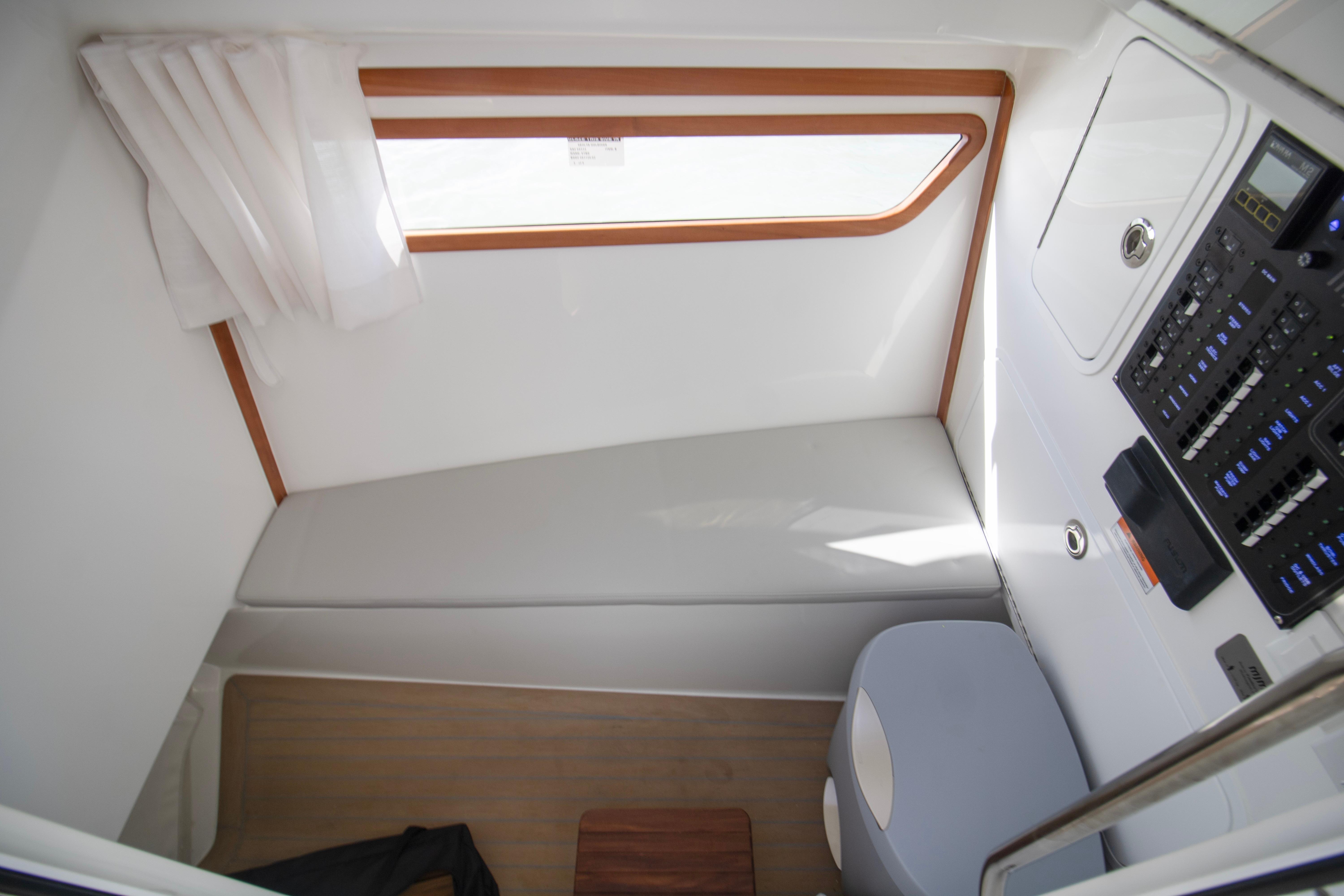 Interior cabin of 2025 MJM 38 X boat with seating and control panel.