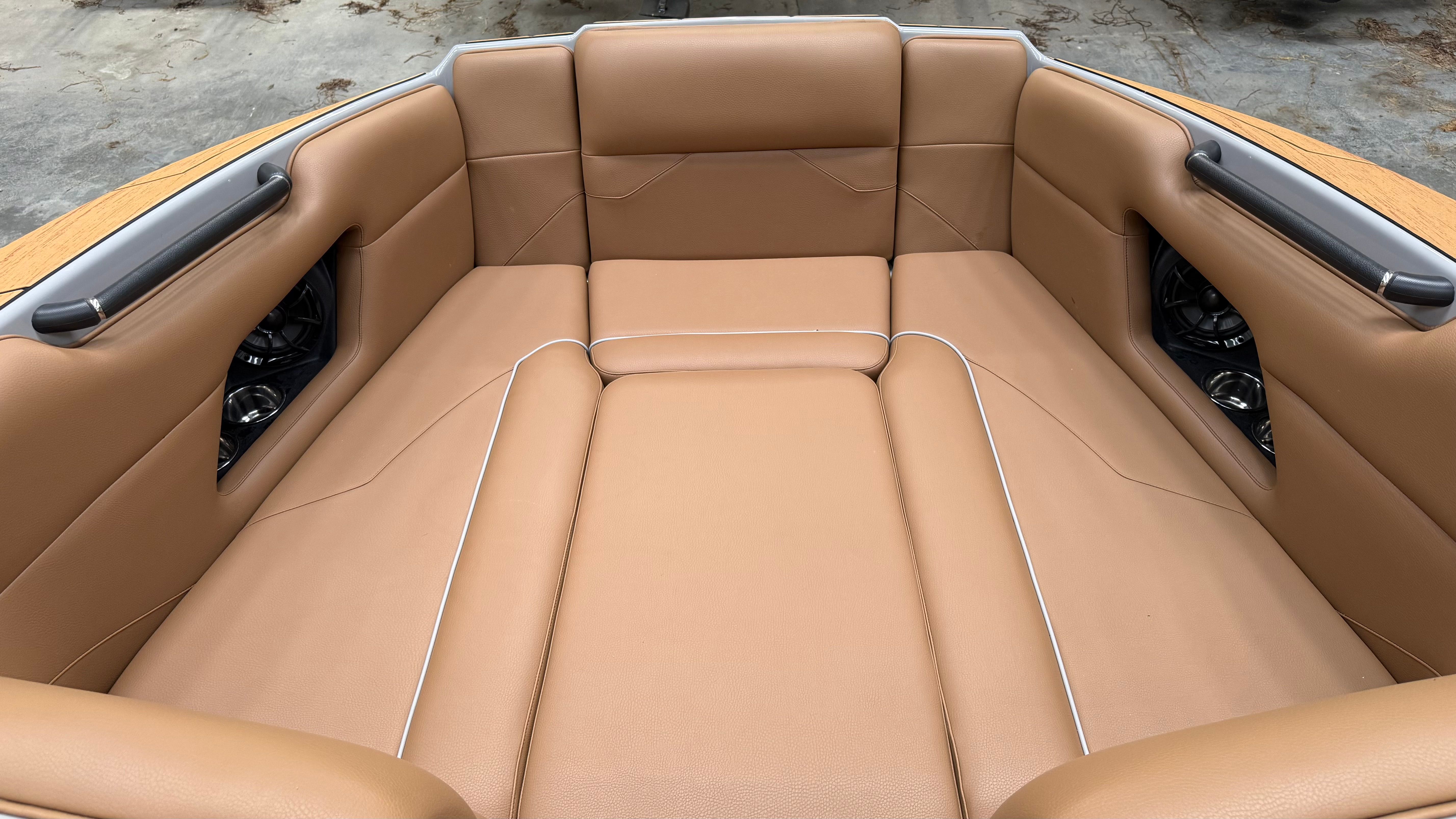 The image shows the bow area of a Malibu Mojo boat with beige upholstery.