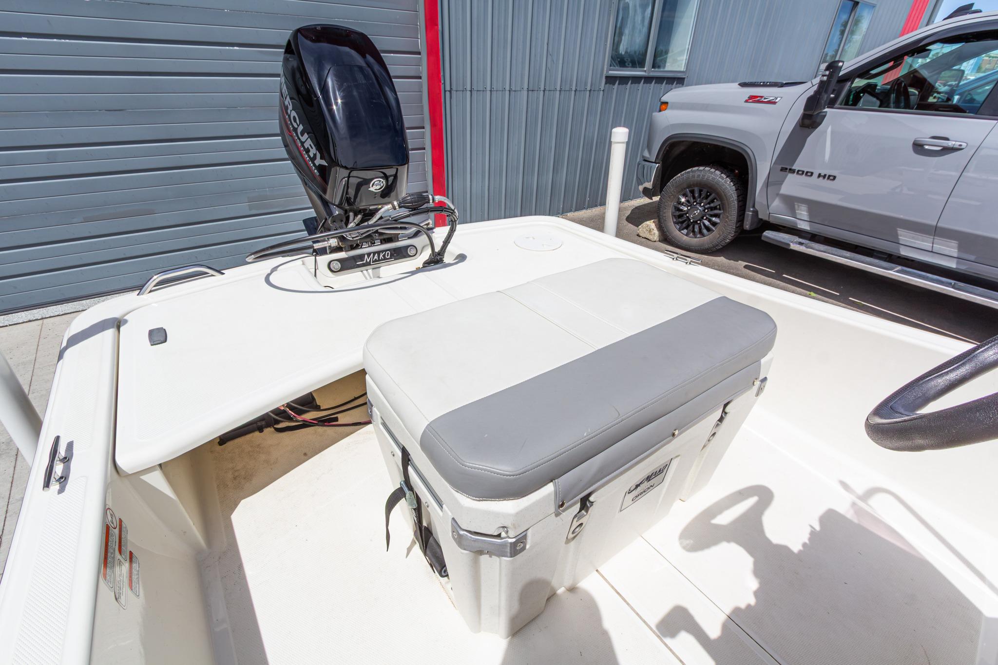 2020 Mako Pro Skiff 15 CC boat interior with Mercury engine, parked beside a truck.