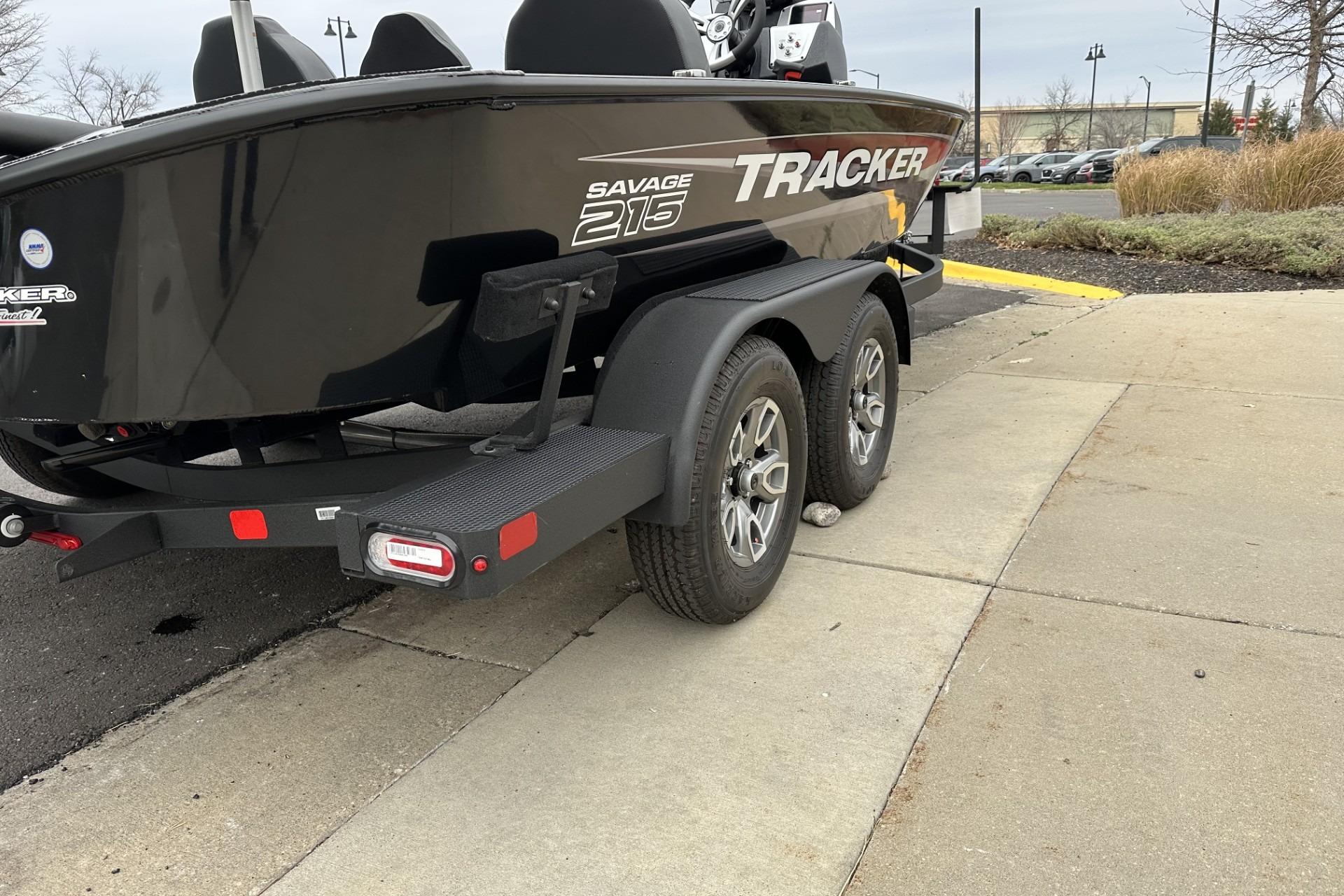 2025 Tracker Savage 215 boat on trailer, parked on pavement.