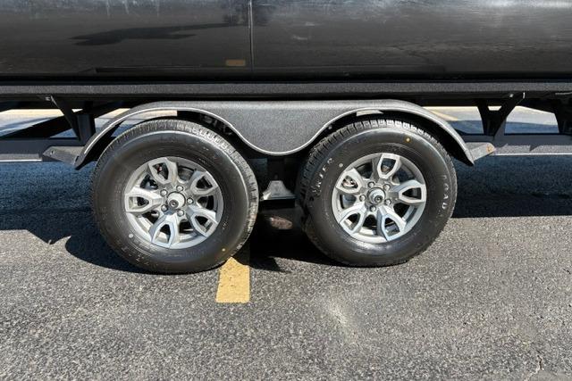 2025 Regency 250 DL3 trailer wheels on asphalt, showcasing dual axle design.