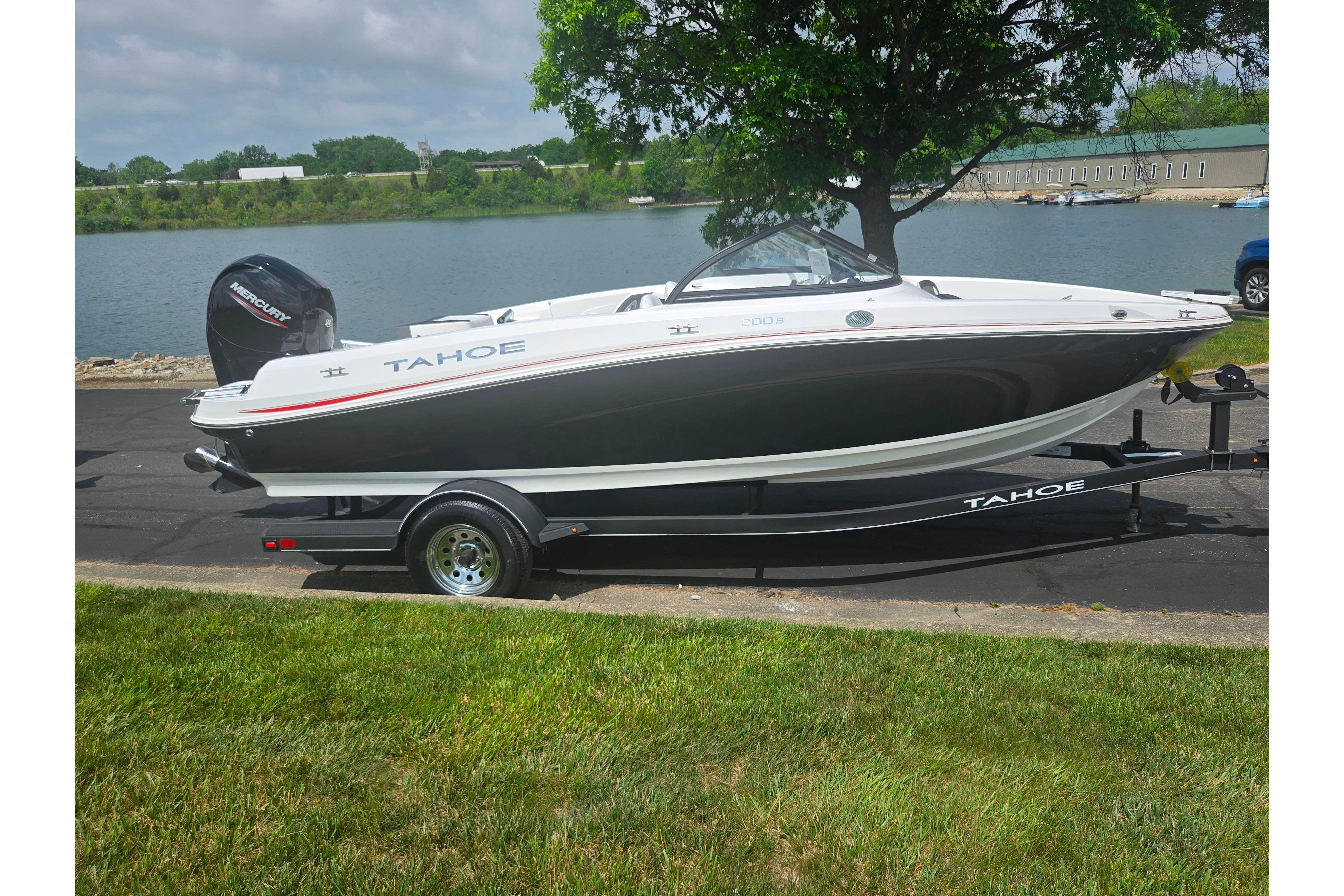 2023 Tahoe 200 S boat on trailer by a lakeside, under a tree.