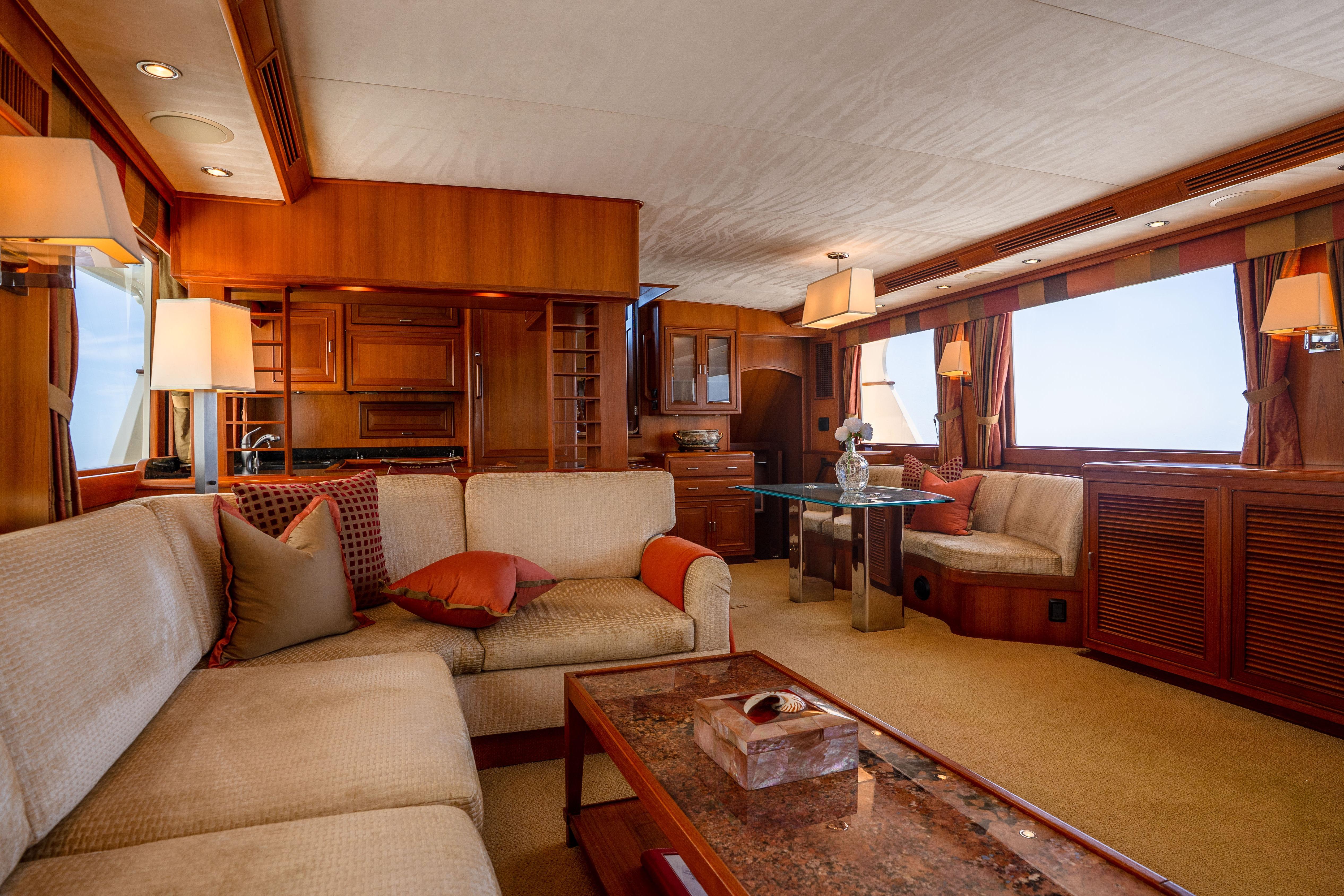 Luxurious interior of a 2006 Fleming 75 yacht with elegant wood finishes and plush seating.