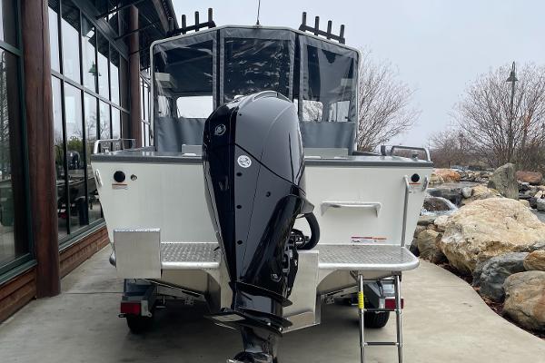 2024 Spartan 215 Athens boat with powerful outboard motor, parked outdoors.