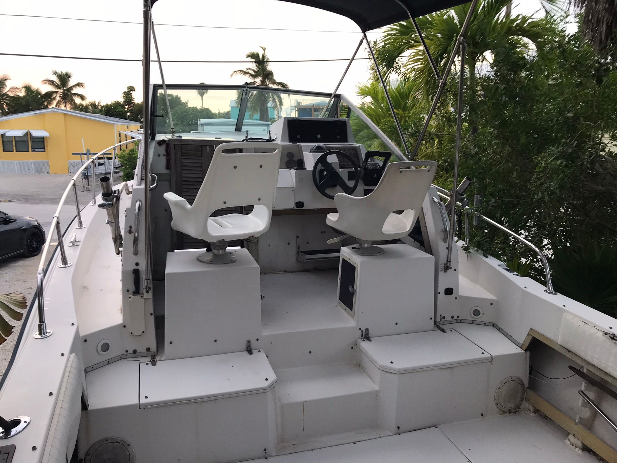 The image shows the cockpit of a 1990 Grady-White Sailfish with two white seats.