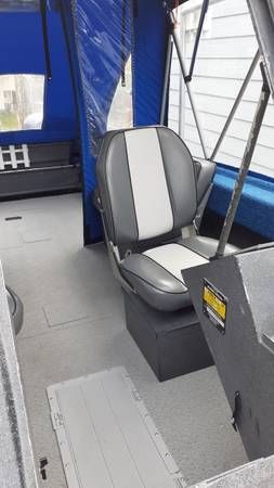 Interior view of a boat with a gray seat and blue canopy.