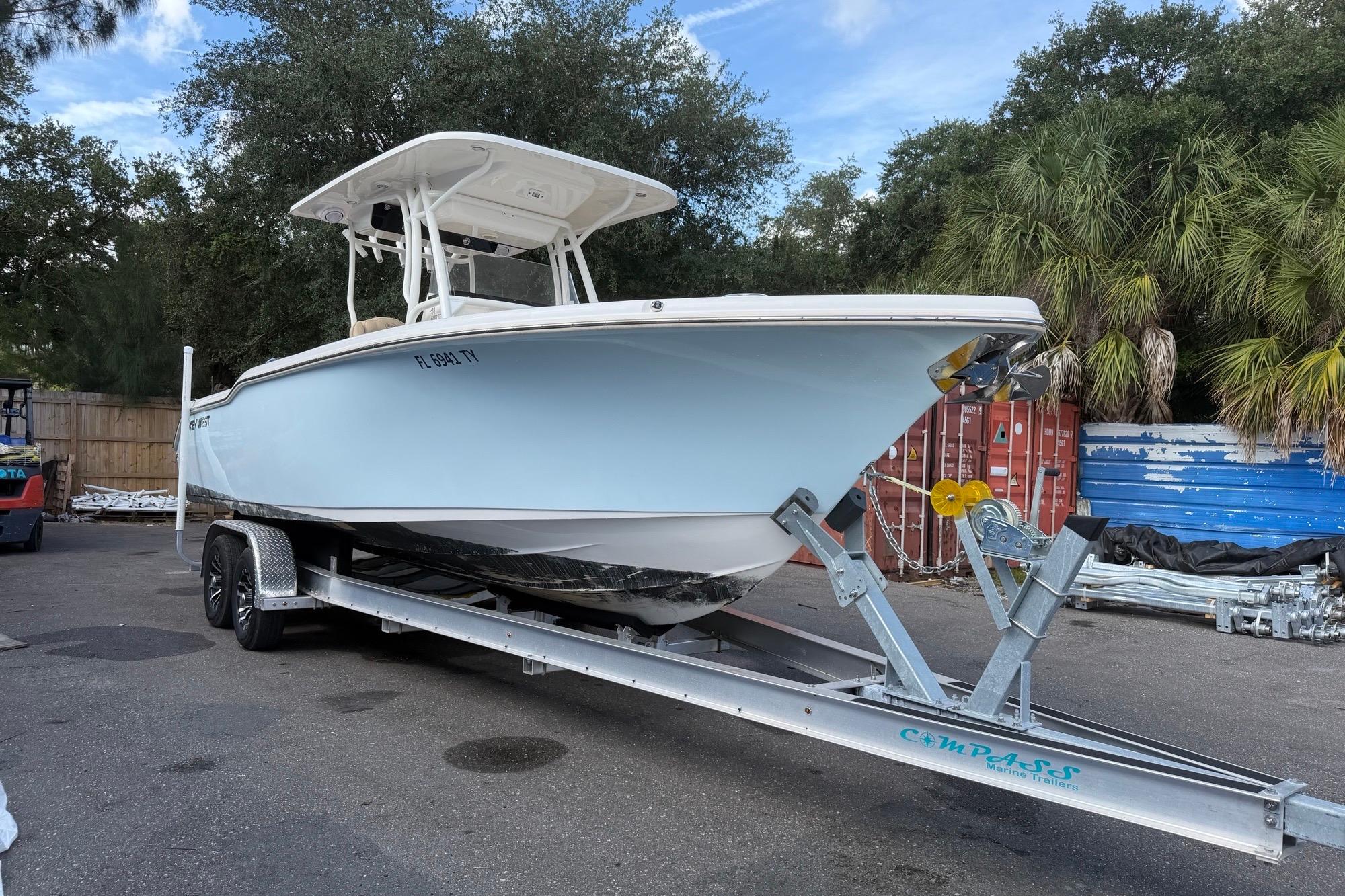 2019 Key West 263 FS boat on trailer, parked outdoors with trees in background.