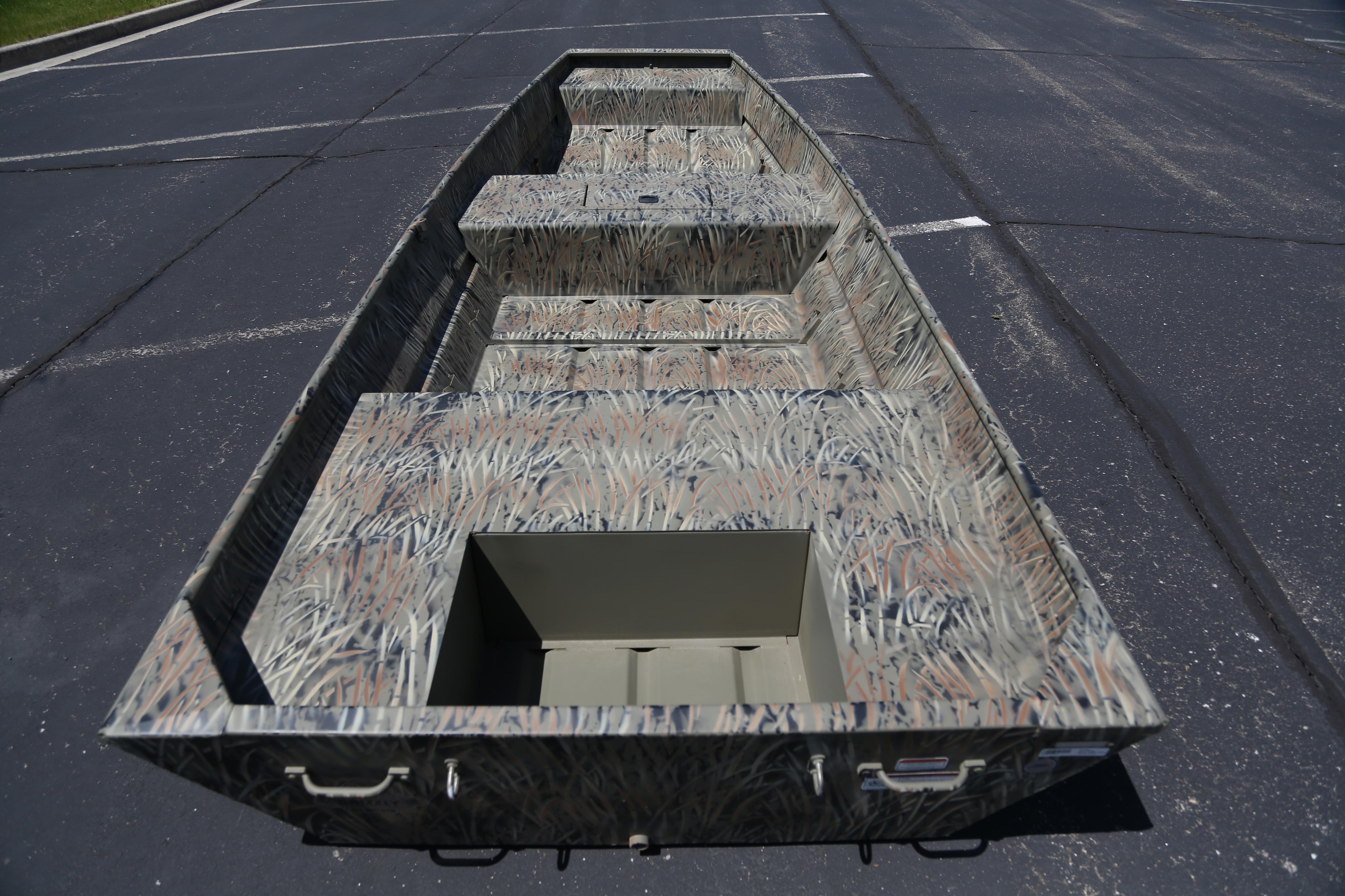 2026 Tracker Grizzly 15 Jon boat with camouflage design on pavement.
