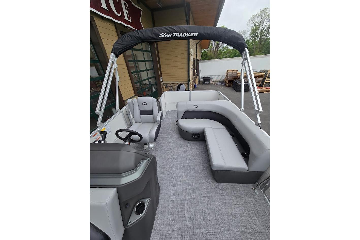 2026 Sun Tracker Party Barge 18 DLX pontoon boat with gray seating and canopy.